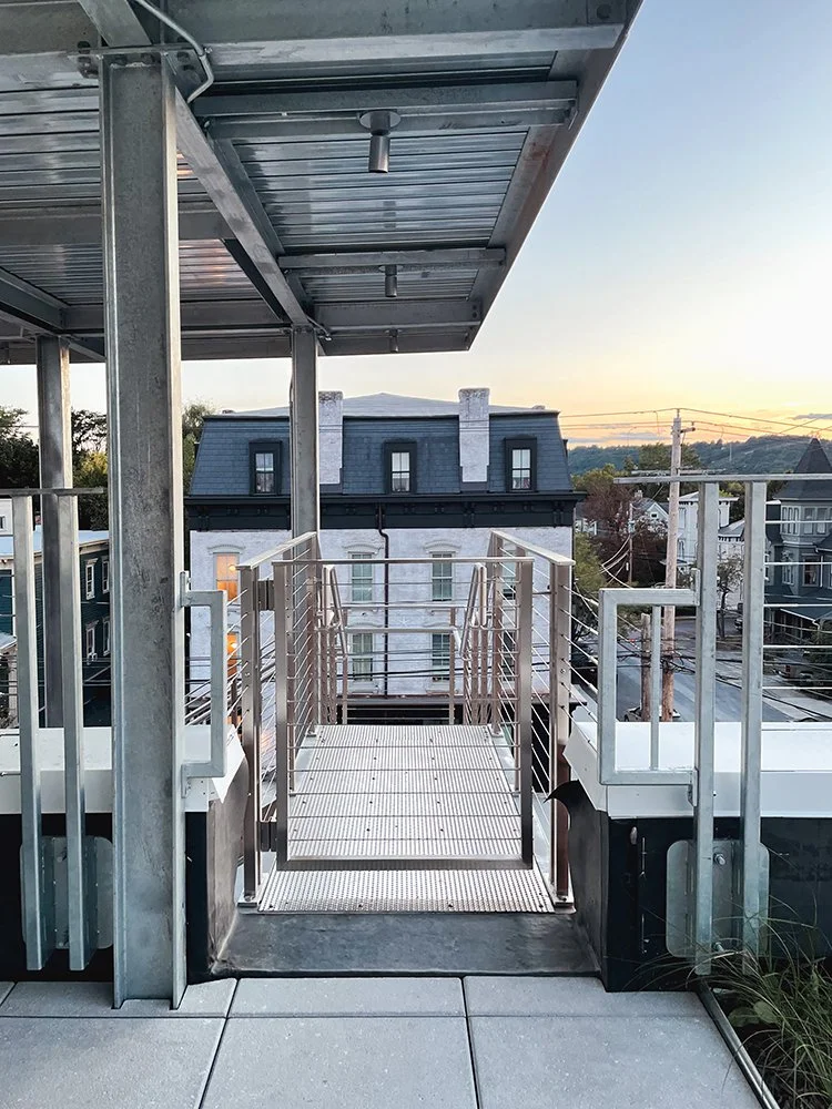 A fire escape gate with view of Hudson, NY sunset