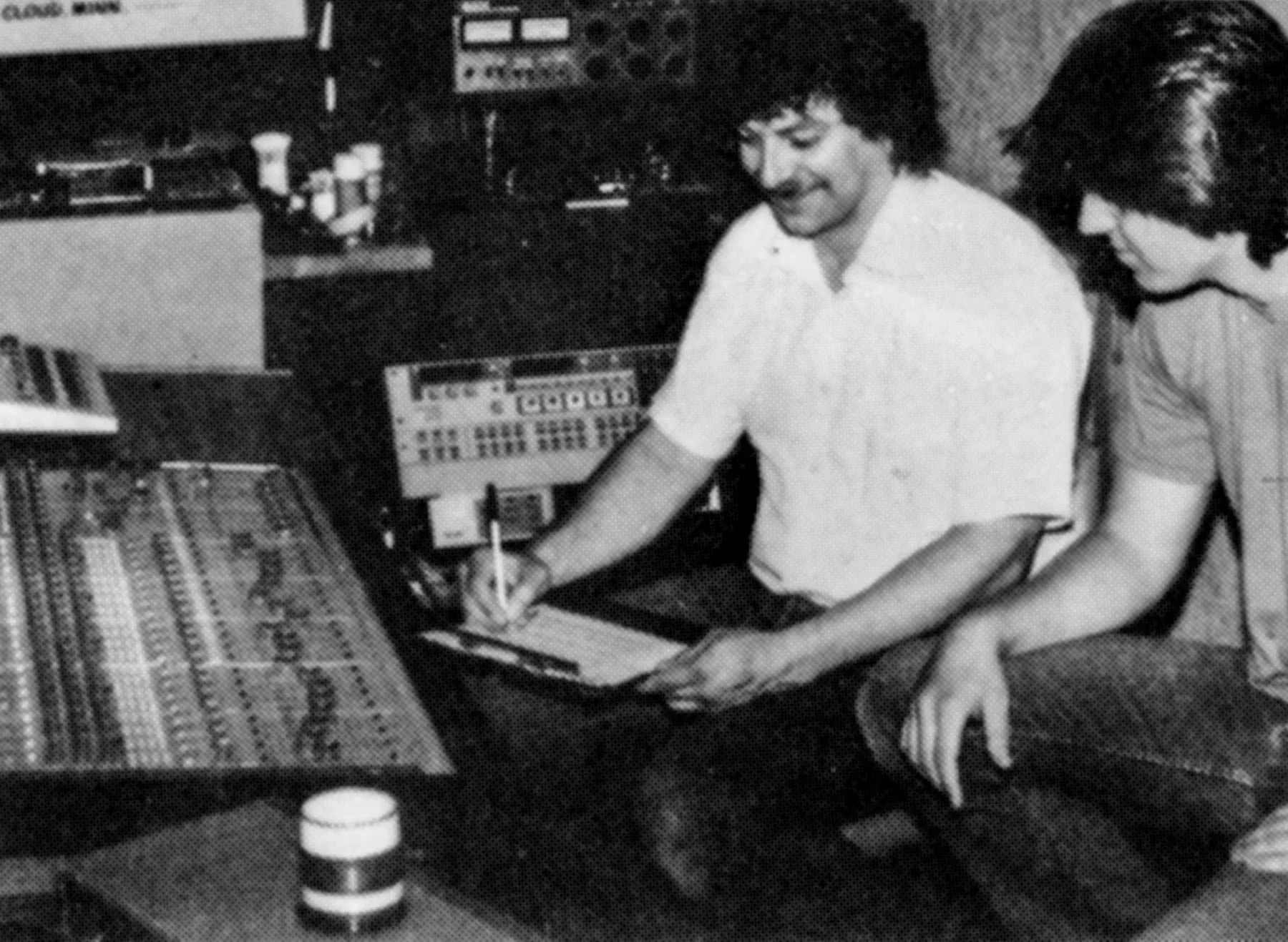Two men working with audio equipment in a recording studio.