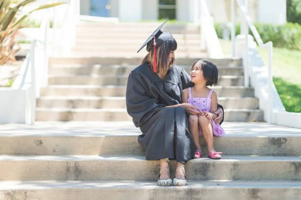 graduate in cap and gown with child