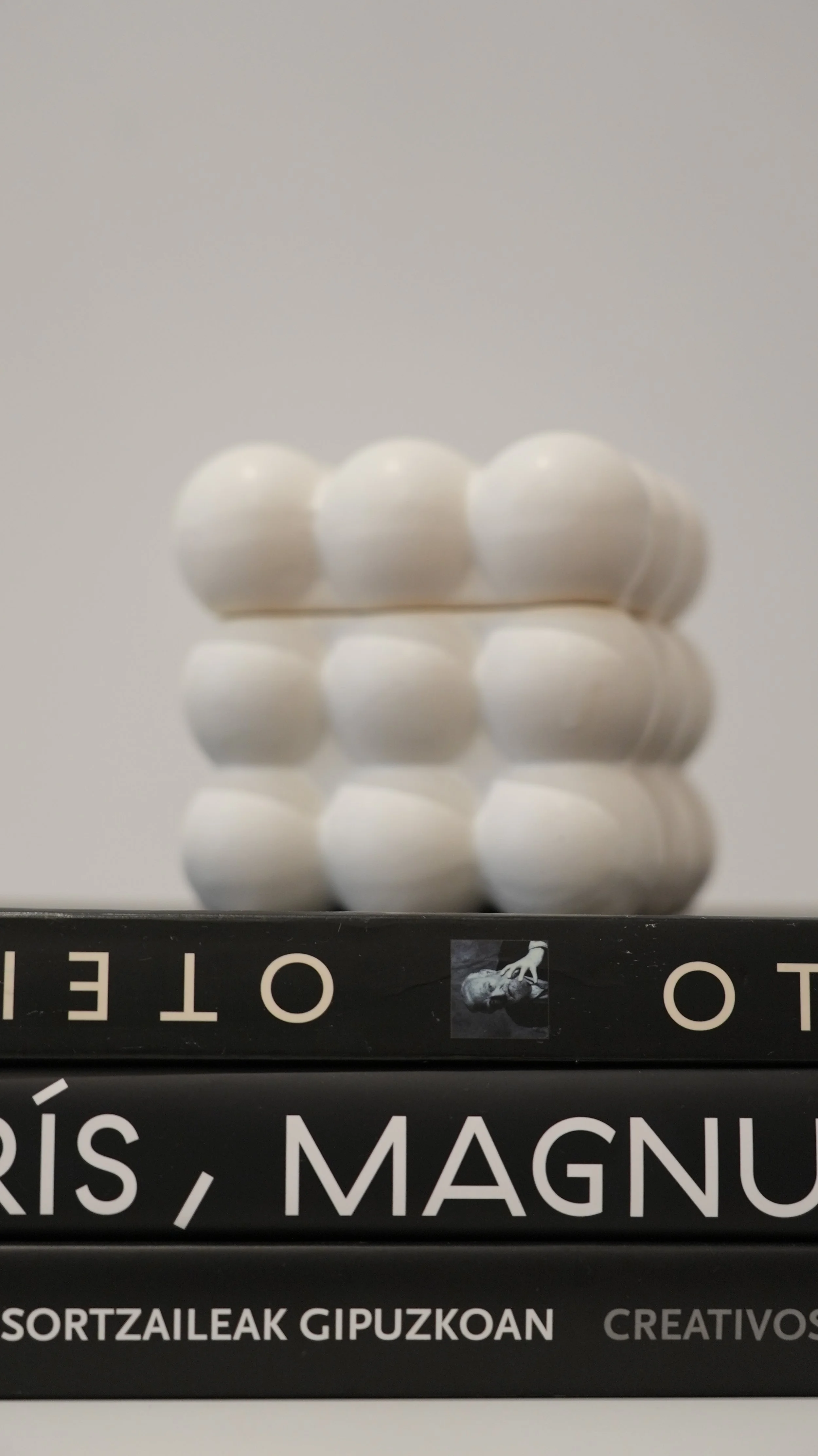 Lote de cinco pastillas blancas apiladas en forma de torre sobre un libro de color negro