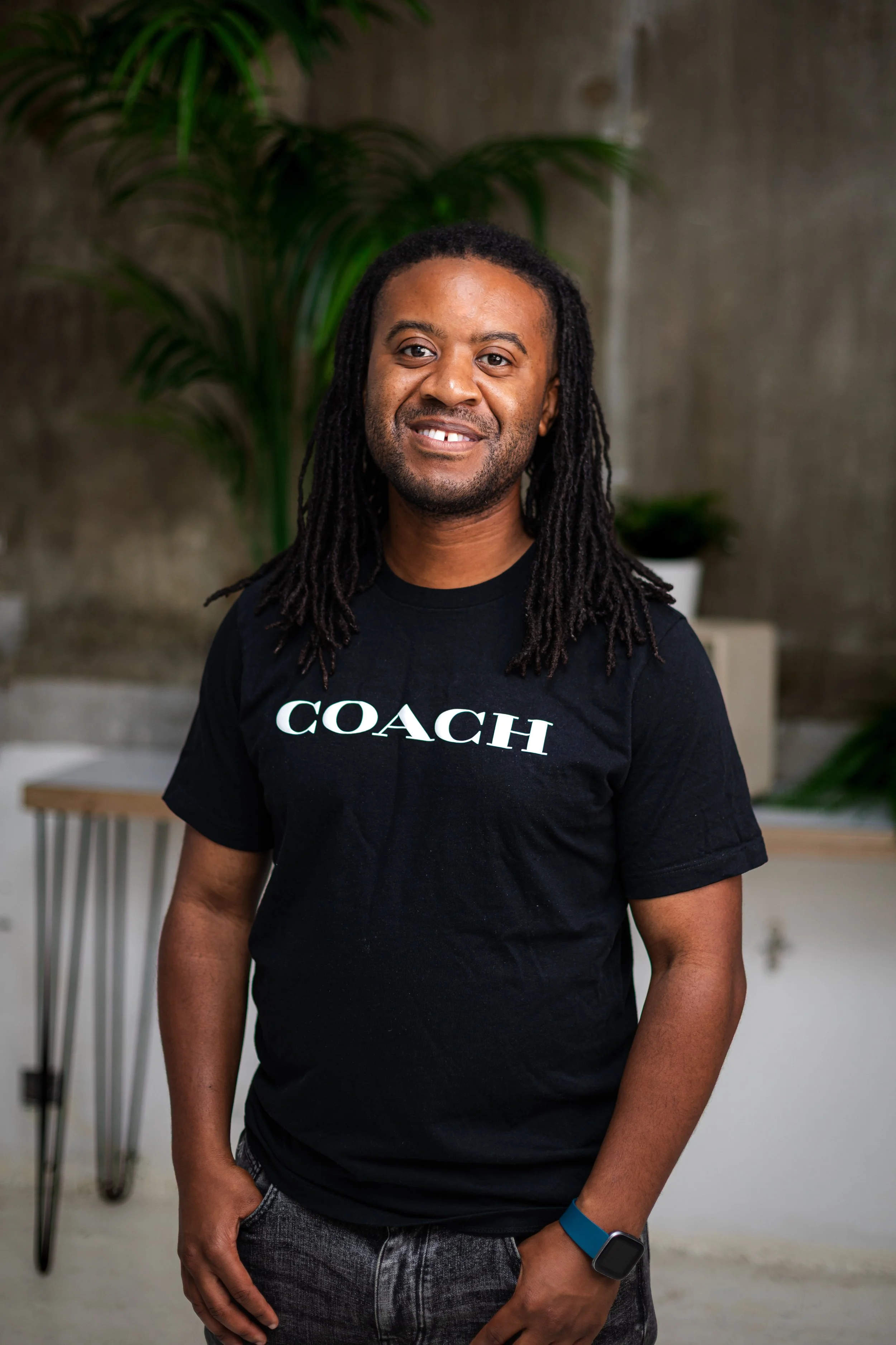 Andy Ayim, serial founder and investor, smiling in a black Coach t-shirt