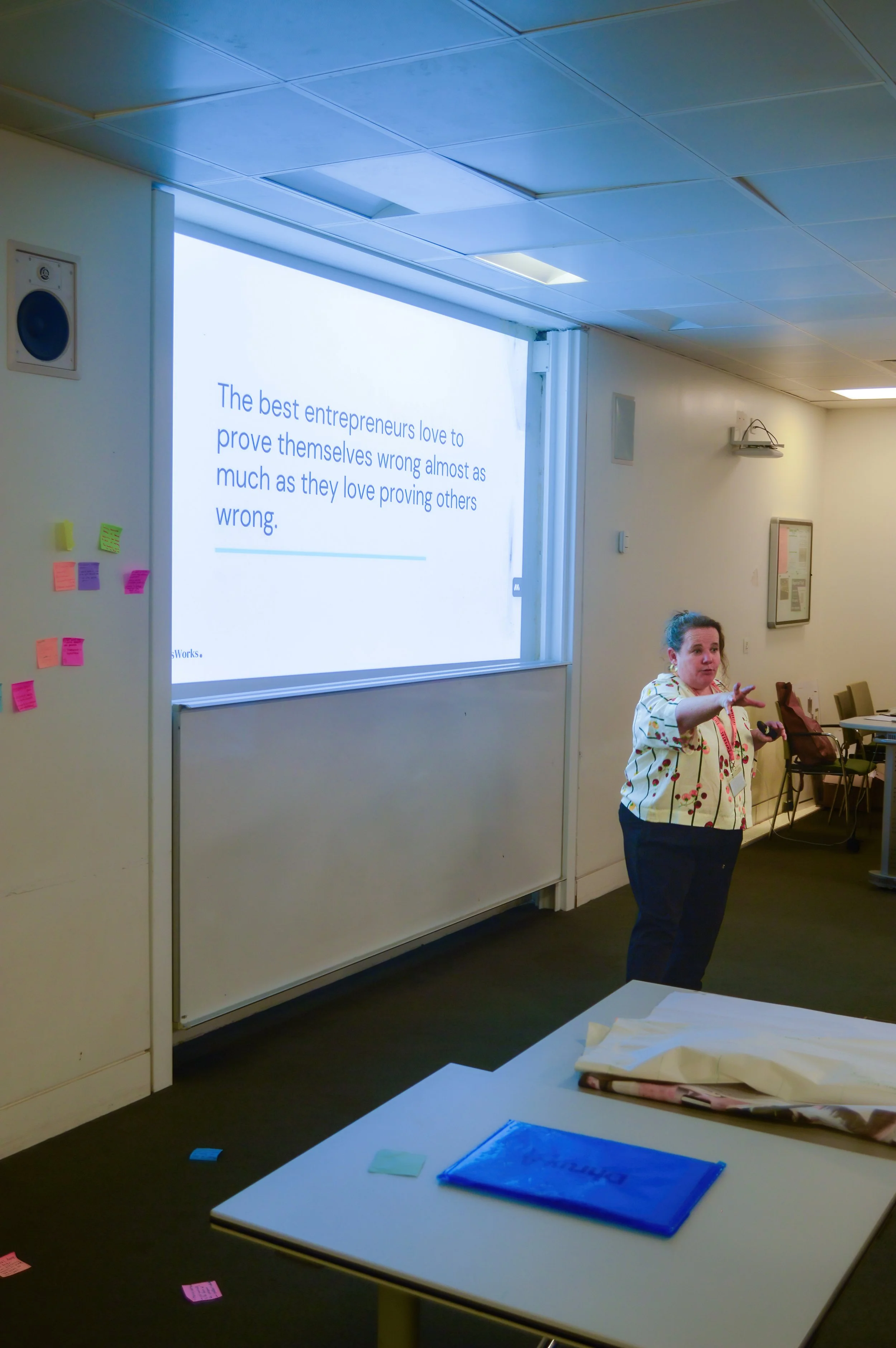 Workshop facilitator presenting in front of a whiteboard with colourful sticky notes