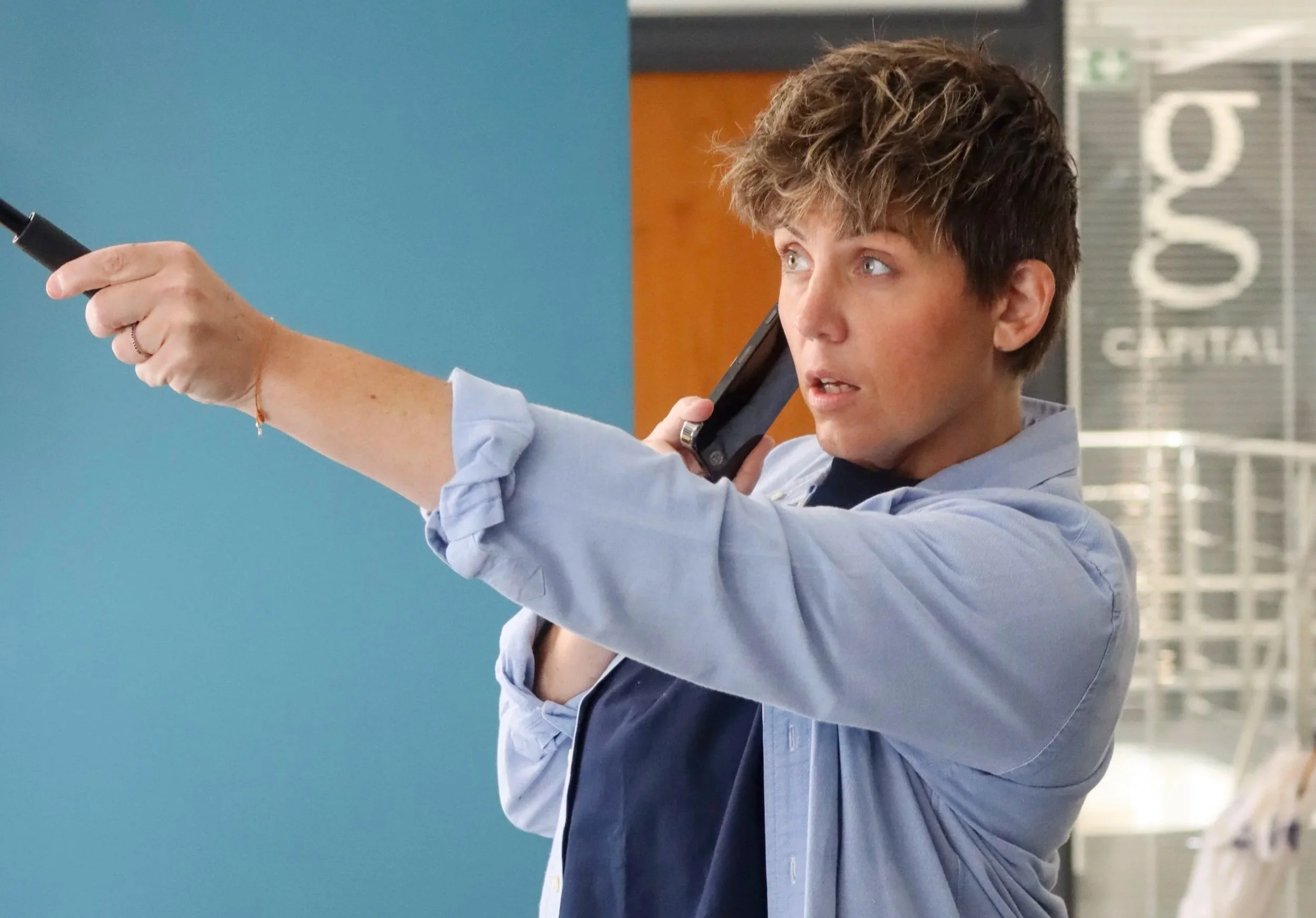 Woman presenting and pointing at a screen during a workshop event