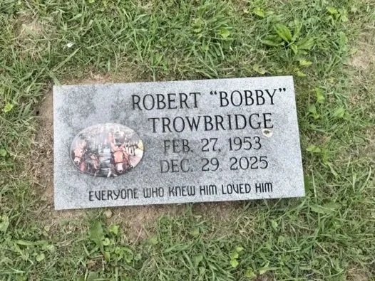 Gravestone for Robert "Bobby" Trowbridge with his birth and death dates, surrounded by grass.