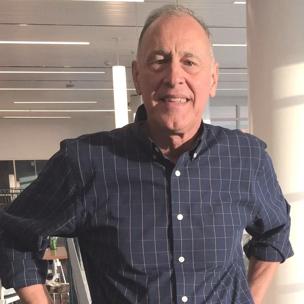 Man with short haircut wearing a blue checked shirt