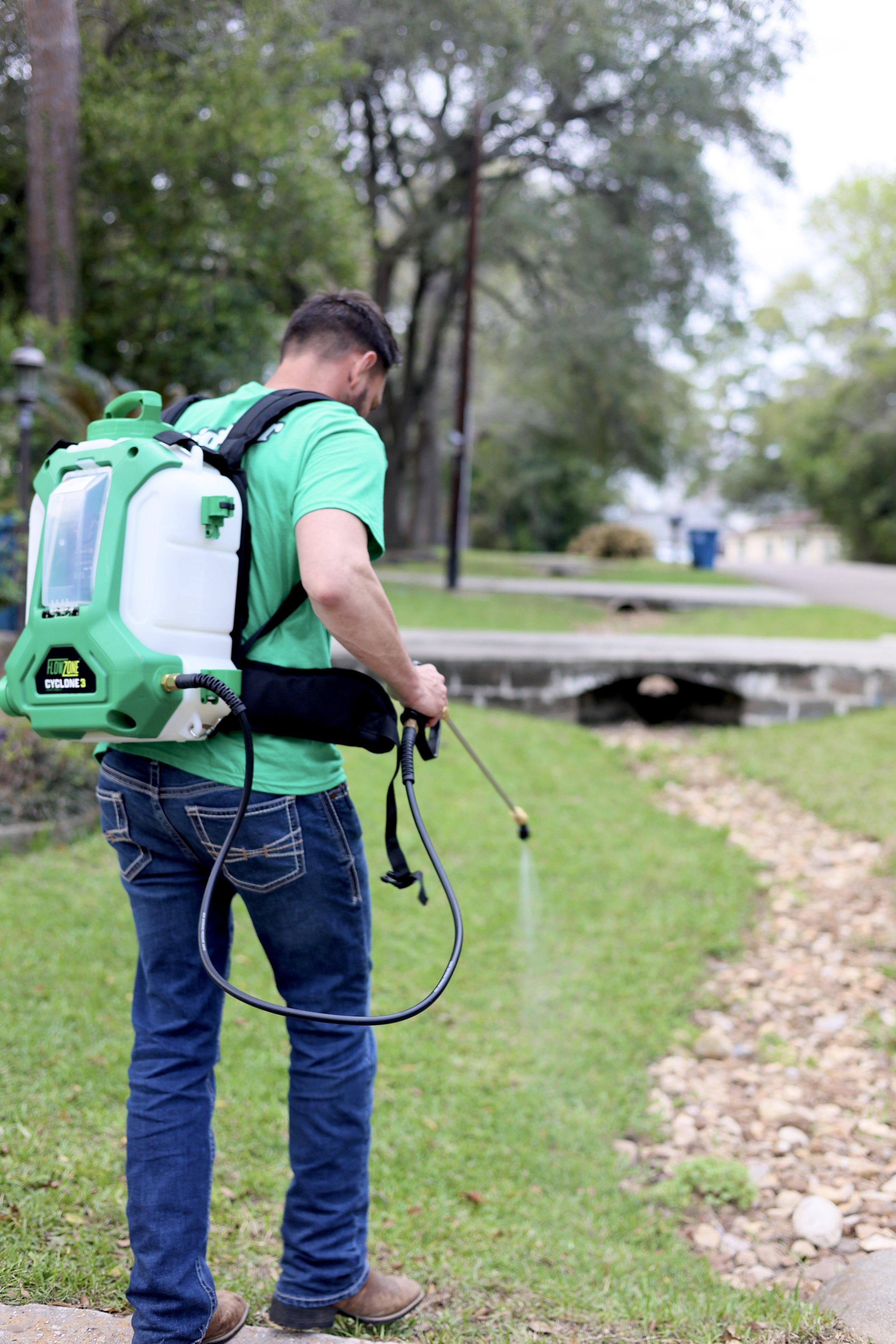 Team member spot spraying weeds with a selective herbicide in a customers lawn.