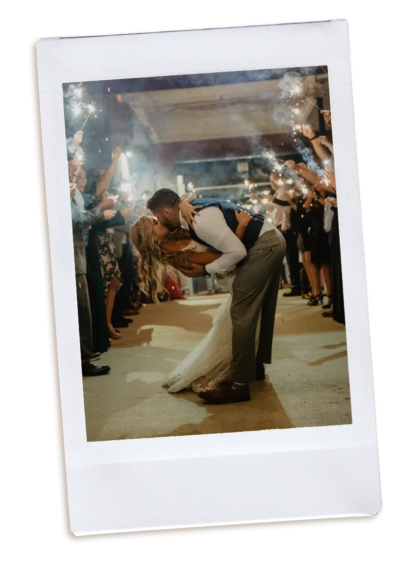 Groom dipping his bride in a romantic sparkler exit