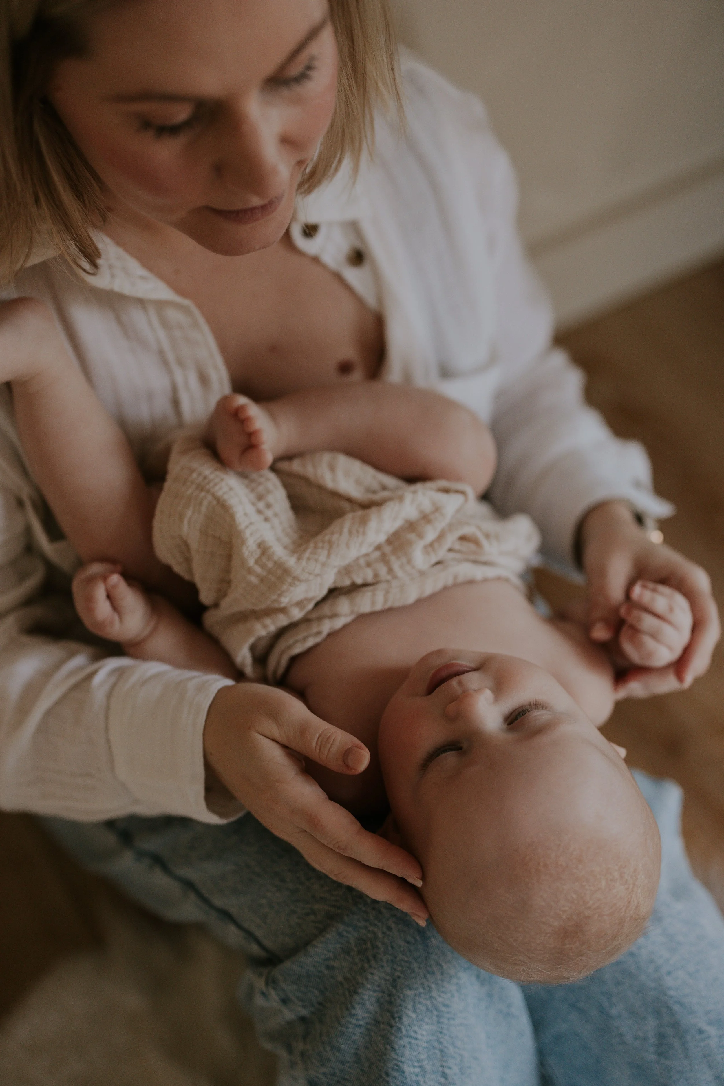Close-up van een moeder die haar slapende baby vasthoudt en knuffelt.