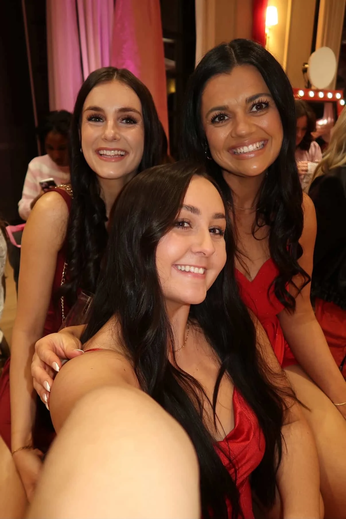 group of tanned women smiling as they take a selfie