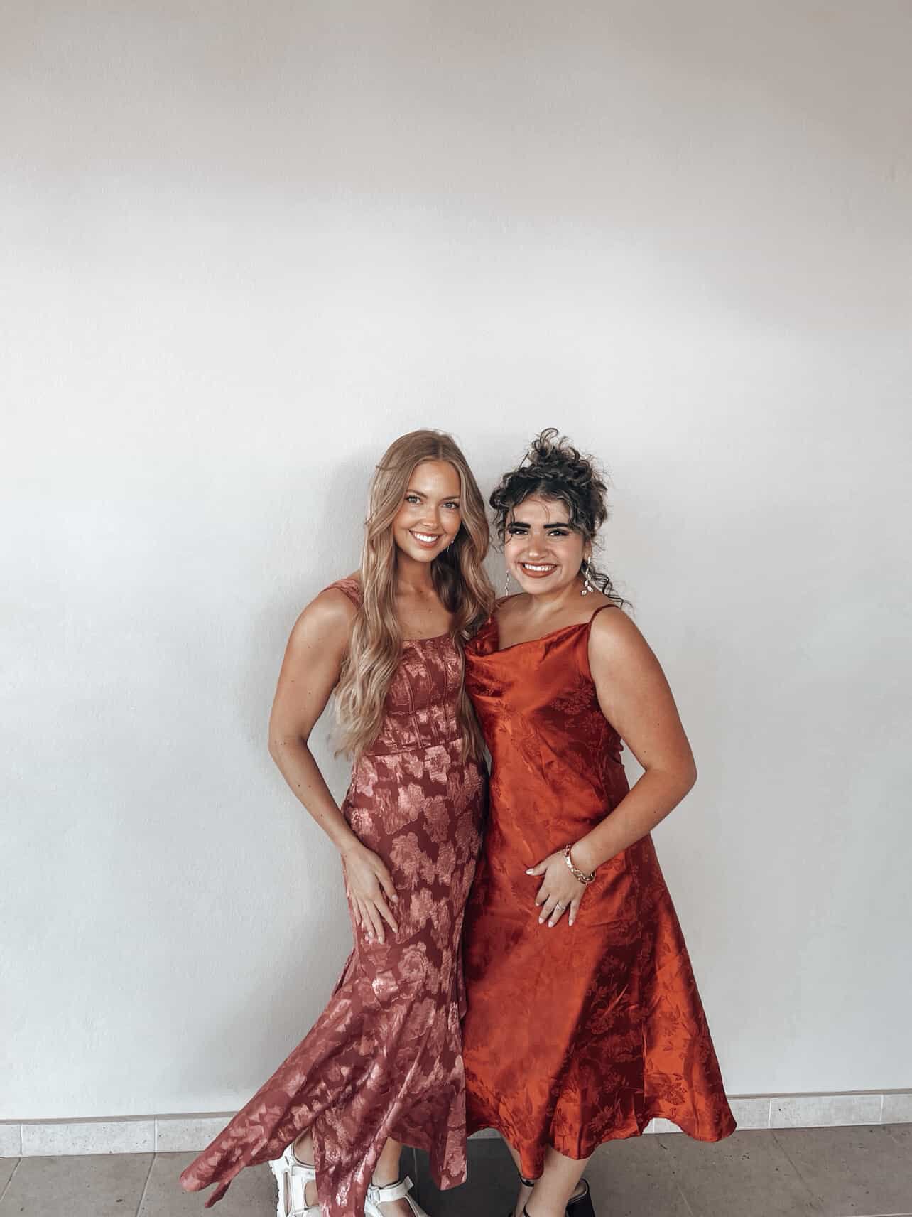 two tanned women embracing