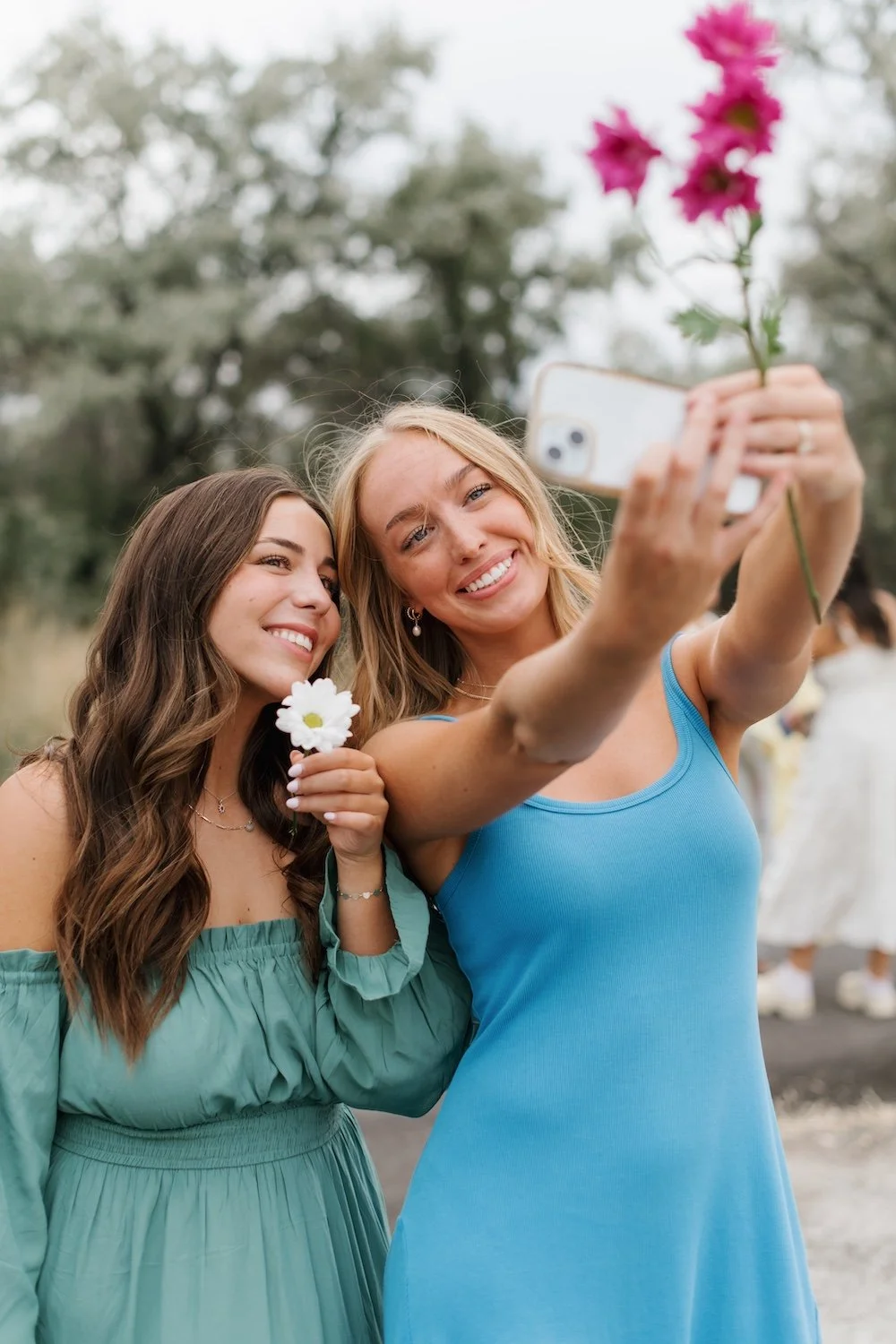 Two girls taking a selfie of their custom matched skin color airbrush tans