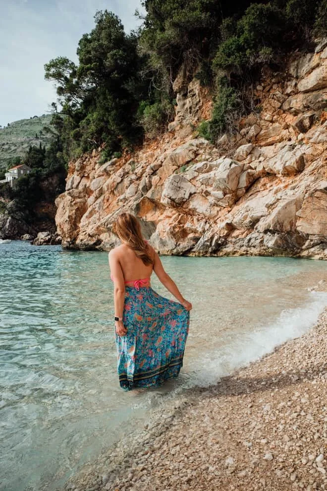 Woman with airbrush spray tan walking in water on a beach