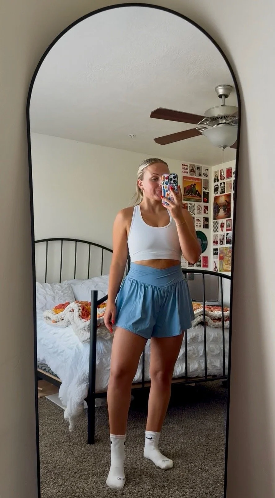 A woman taking a selfie of her airbrush spray tan in the mirror