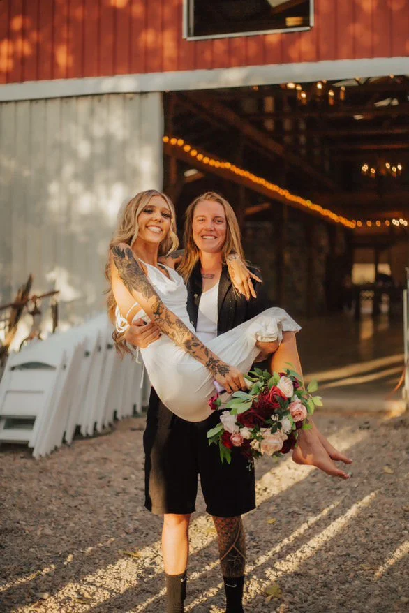 A bride being held up in the air, with a beautiful airbrush tan