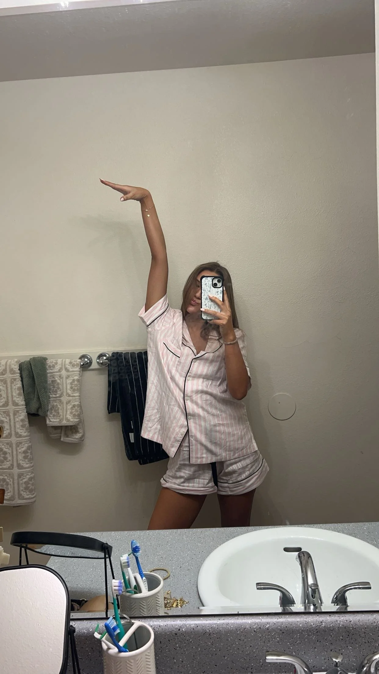 Woman taking a selfie of airbrush spray tan in the mirror