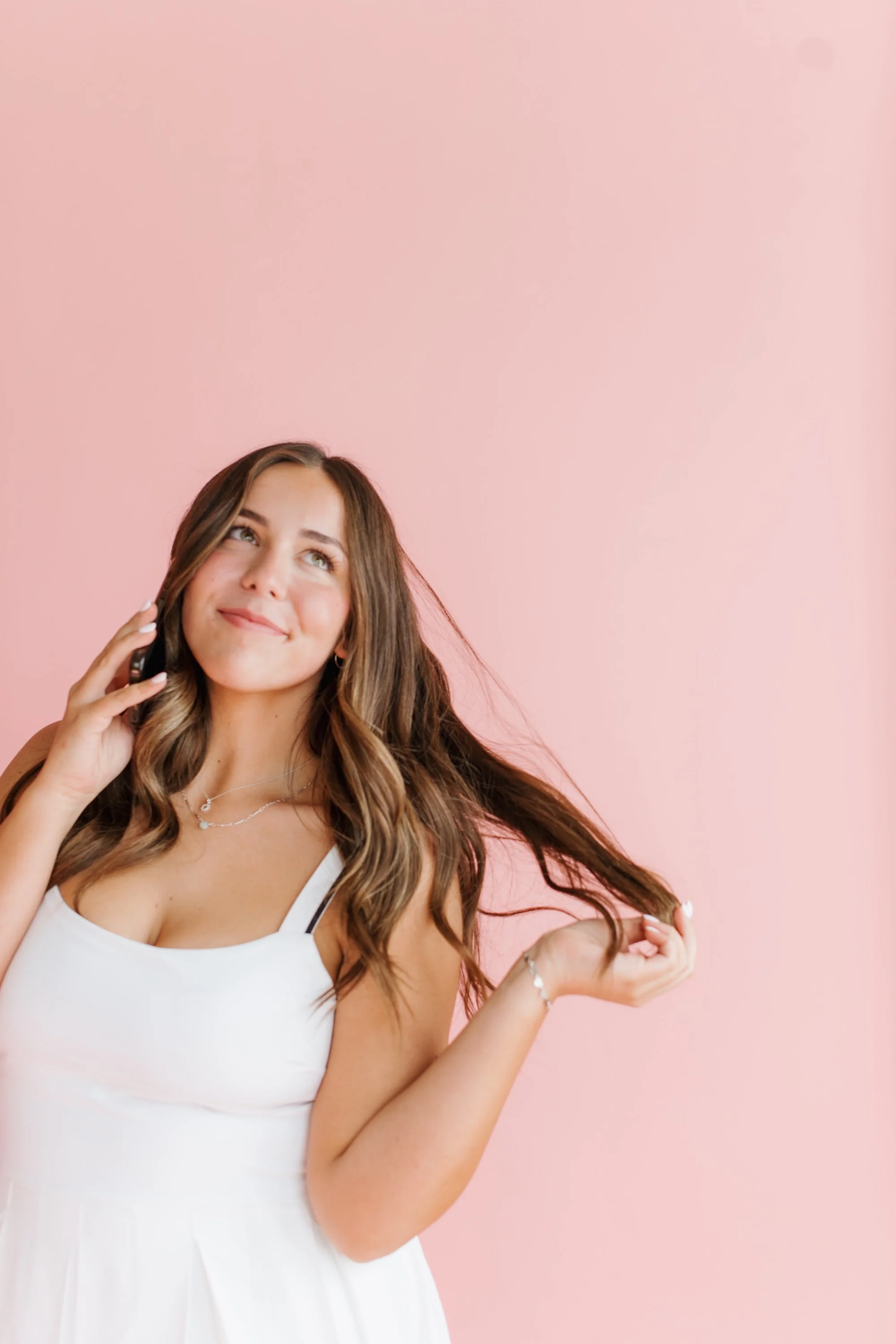 Tanned woman twirling her hair in her hand