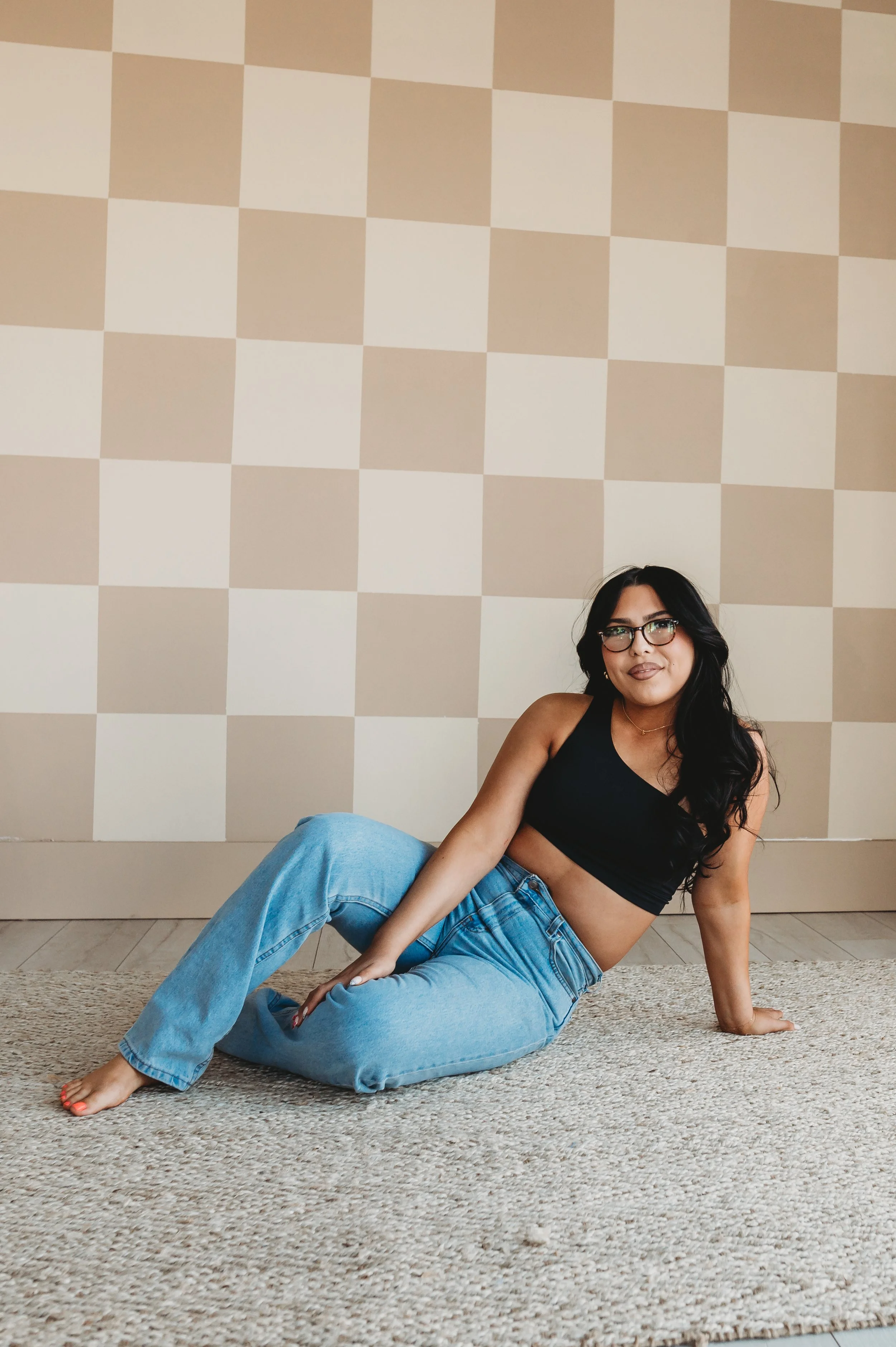 A tanned woman sitting on the ground