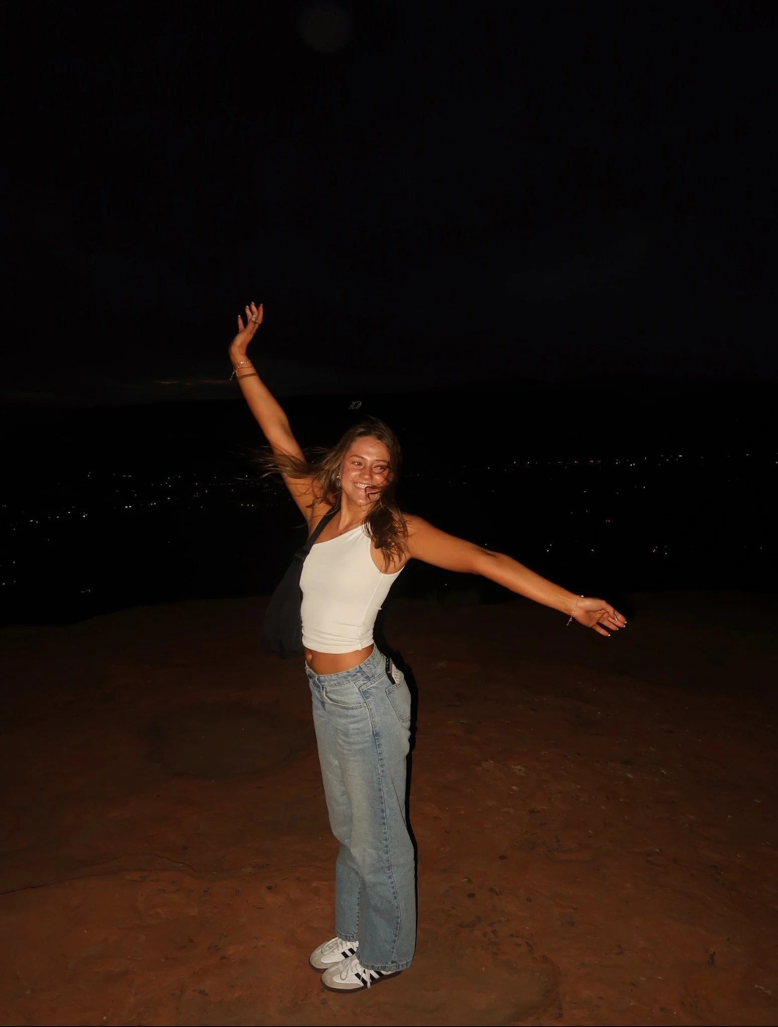 Girl showing off her airbrush spray tan with her arms in the air