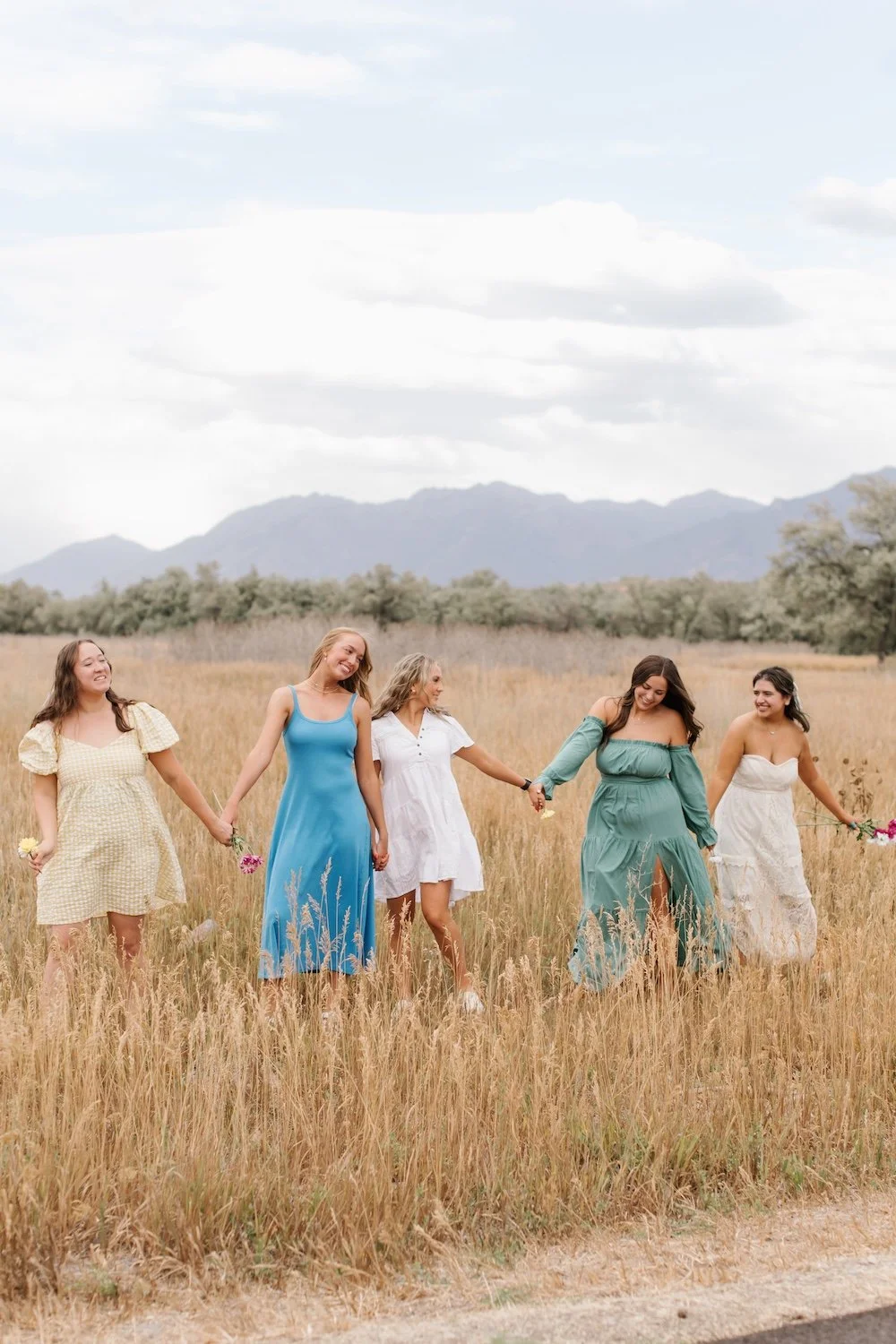 Girls holding hands walking in field