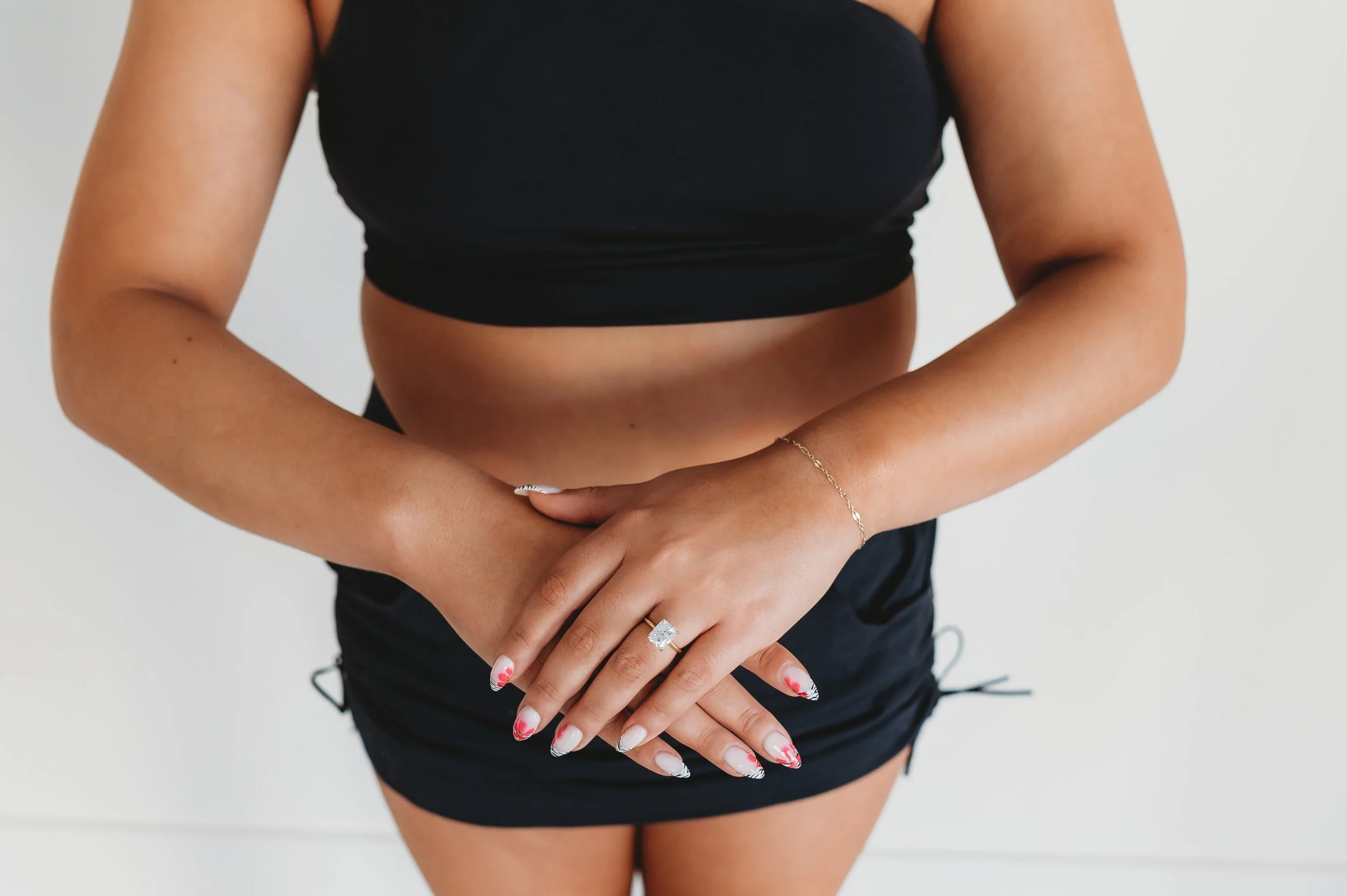 A tanned woman with her arms crossed in front of her body
