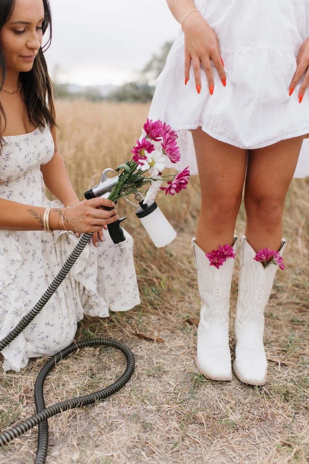 Experienced airbrush spray tan artist holding her equipment and flowers