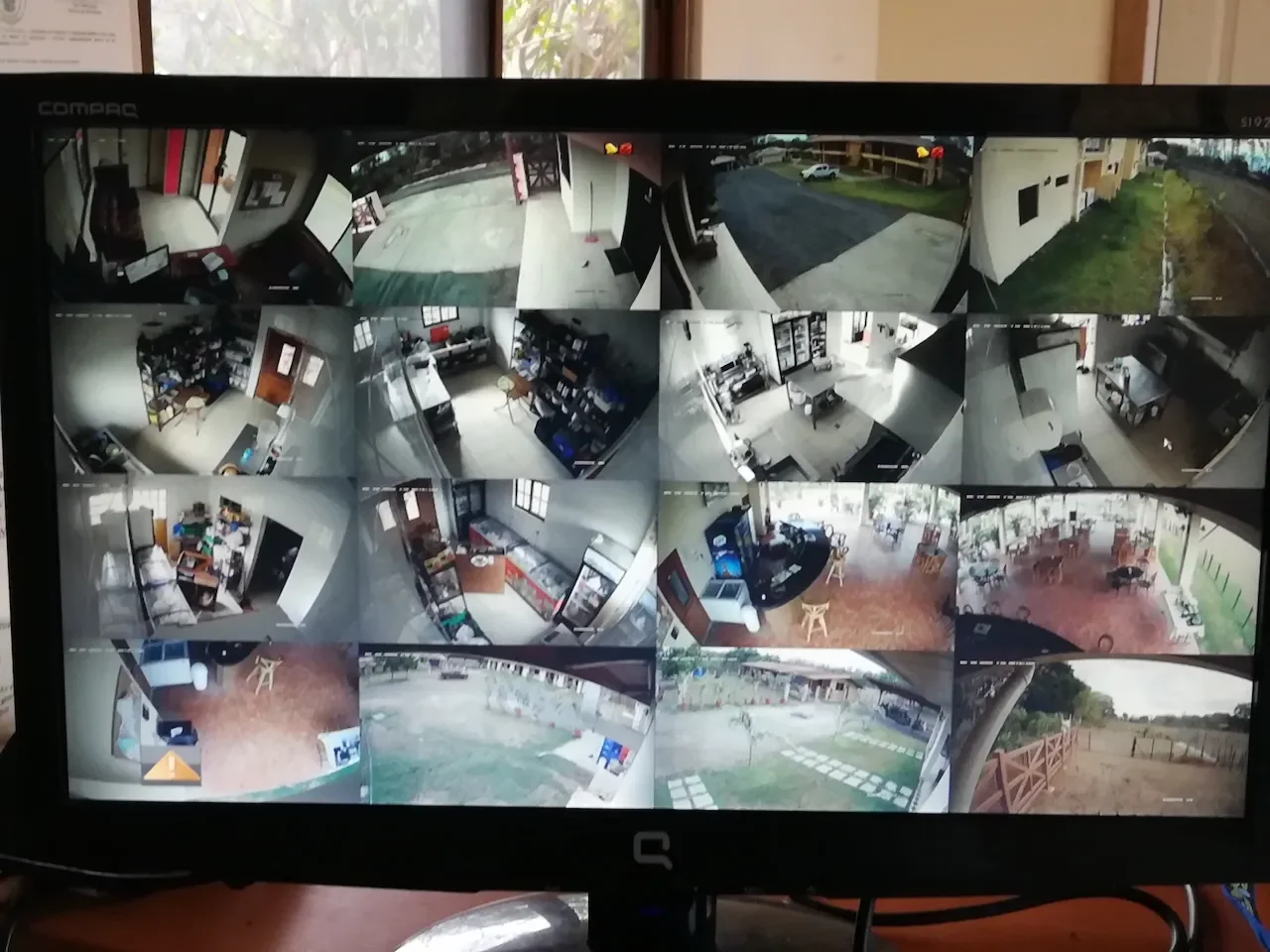 Pantalla de seguridad con múltiples cámaras mostrando diferentes áreas de un establecimiento y exteriores.