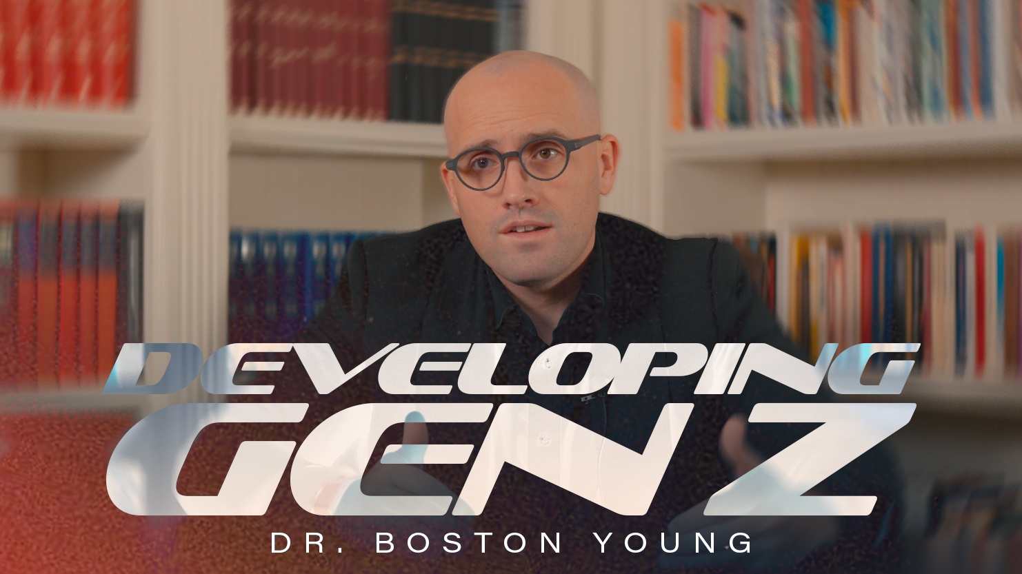 A man with a bald head and glasses sitting in front of bookshelves in an office or library. Overlaid text reads "Developing Genius" and "Dr. Boston Young."