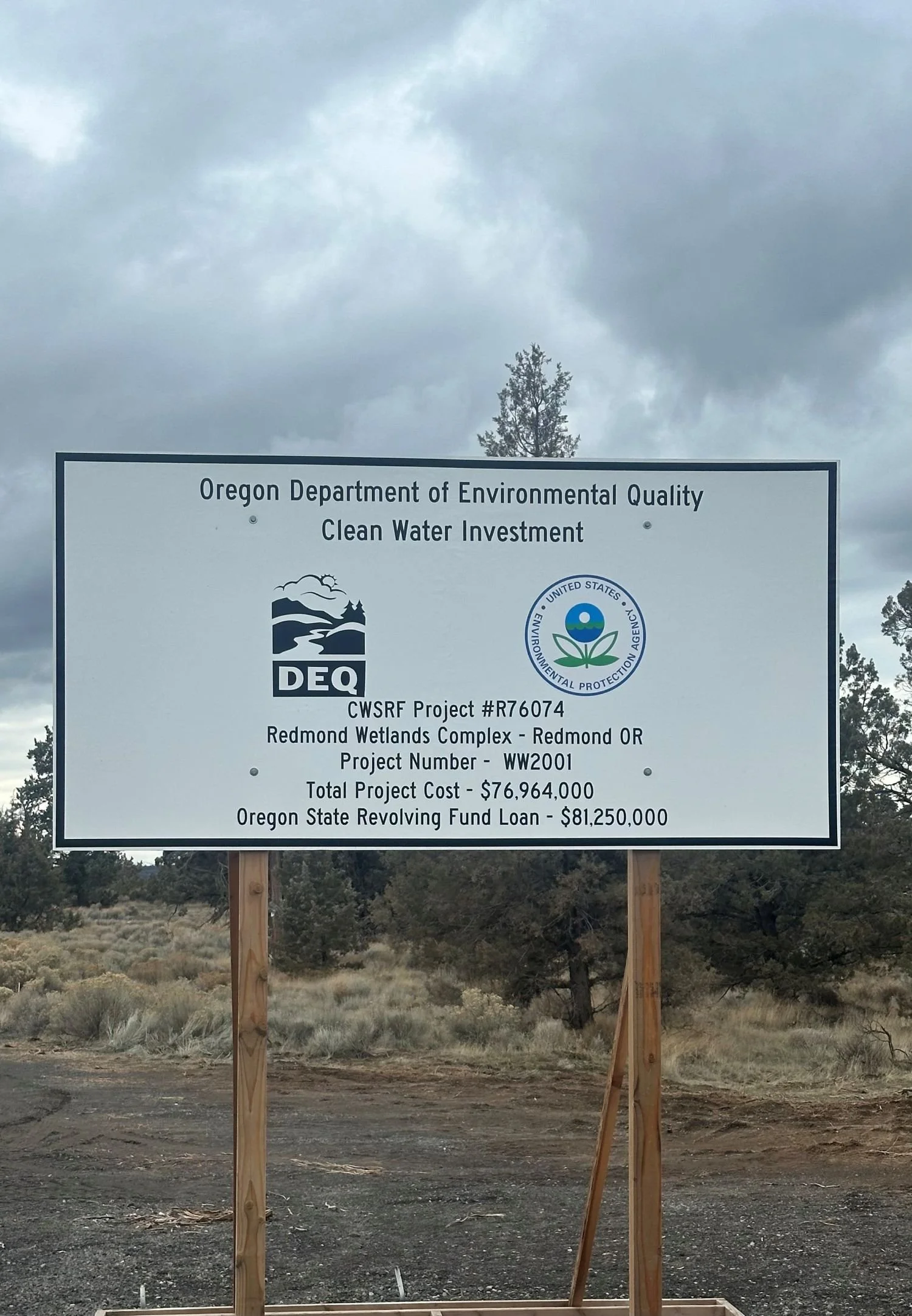 A signboard from the Oregon Department of Environmental Quality informing about a clean water investment project at Redmond Wetlands Complex in Redmond, Oregon, with project details and funding information.