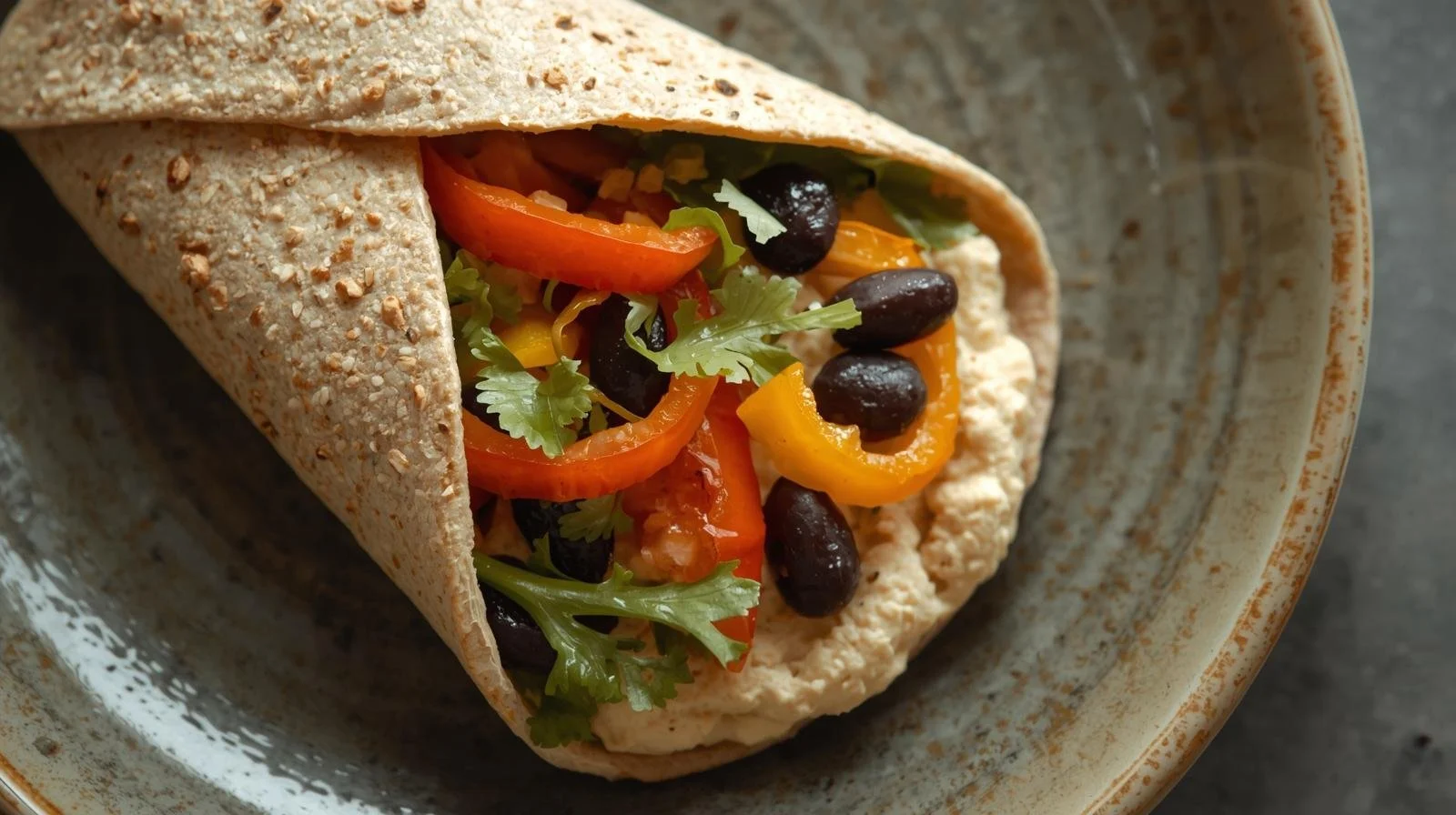 whole-wheat wrap with hummus, vegetables, and black beans in it.jpg