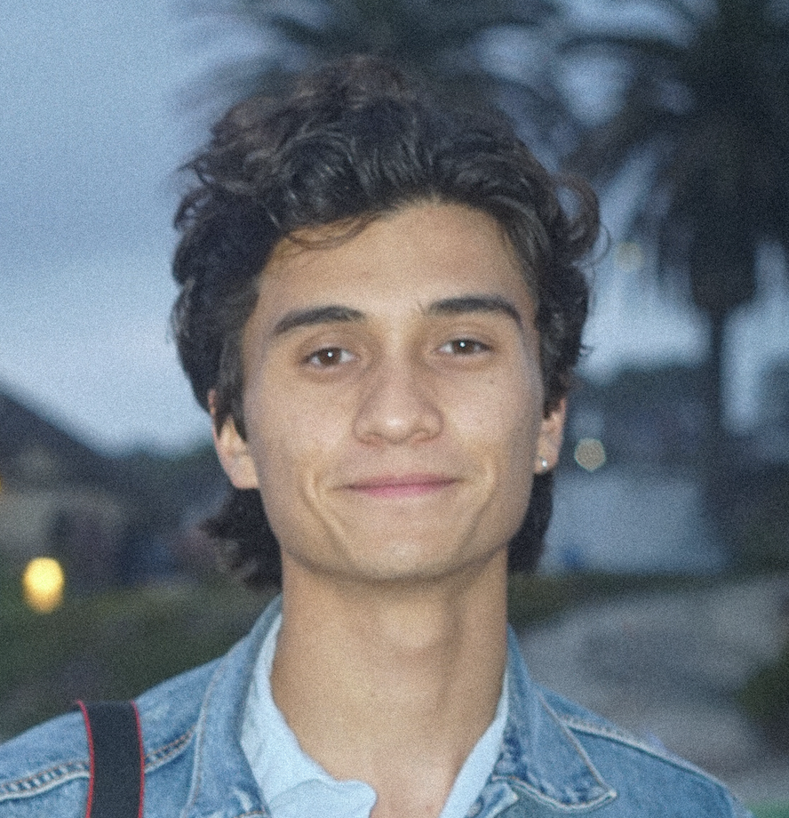 Joey Pascua is on staff at Carmel Church in San Diego. He helps in creative arts, Youtube, videos, Instagram, etc and builds the christian community. Young man with curly dark hair, wearing a denim jacket, smiling outdoors during dusk.