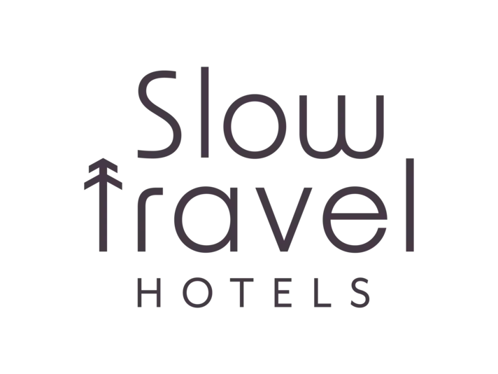 Das Logo des Slow Hotel, bei dem der Text 'slow' und 'hotel' in einer stilisierten Schrift zu sehen ist.