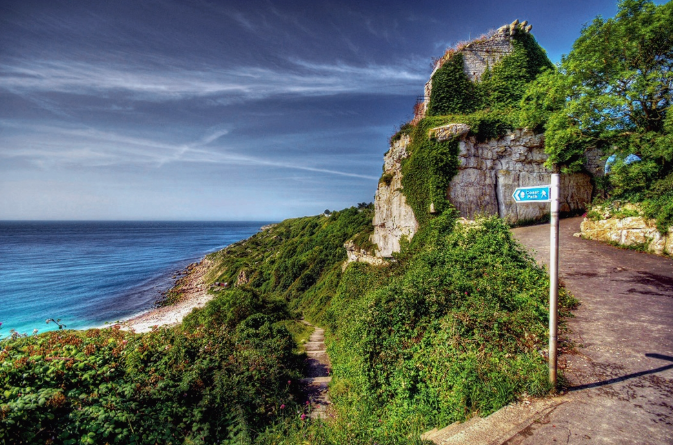 Signposted coastal path leading to a secluded cove.