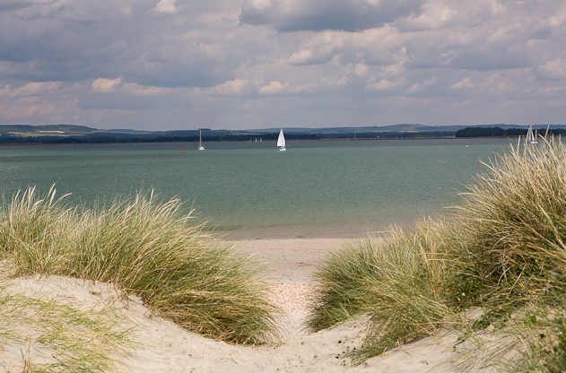 Looking out to sea at some sailboats off the sandy shores of East Head beach