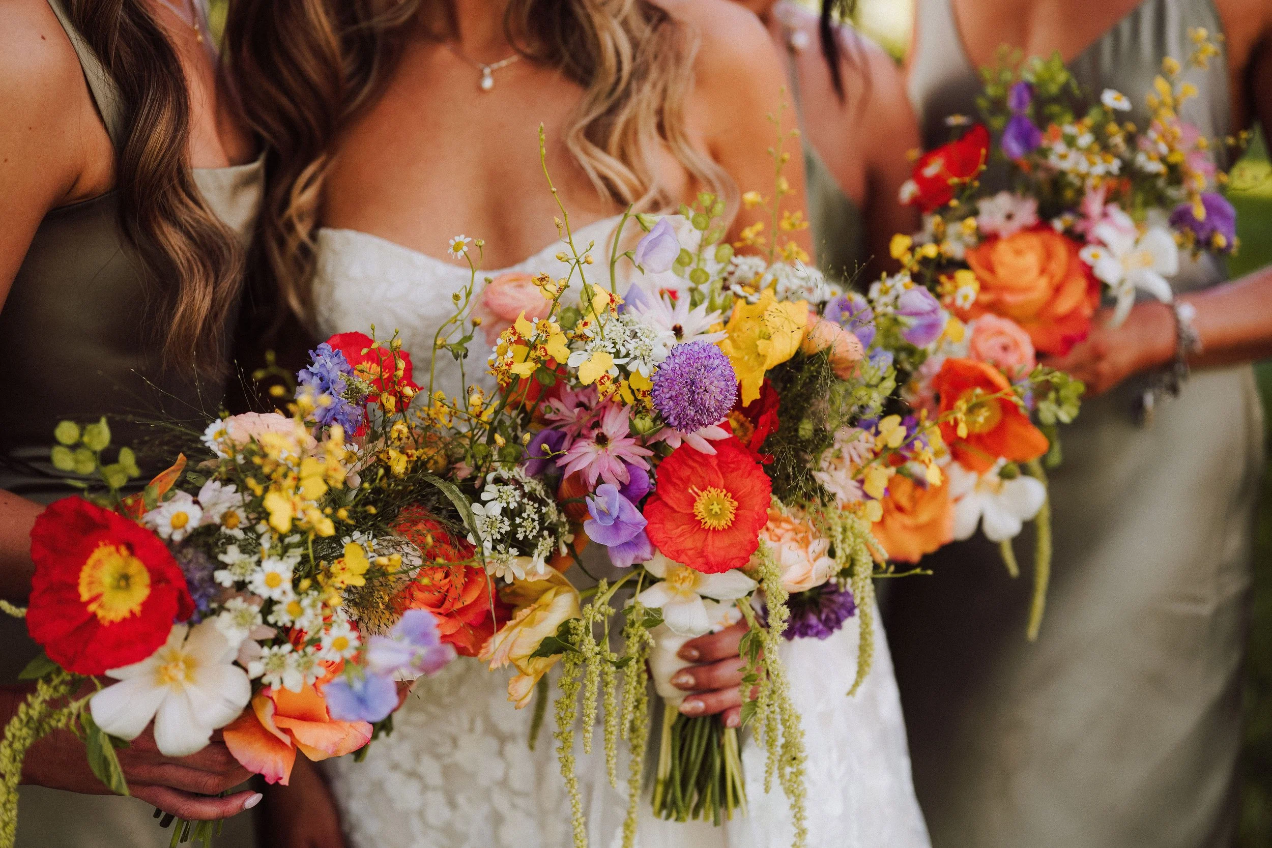 A bride holding a colorful bouquet of flowers during a wedding celebration.