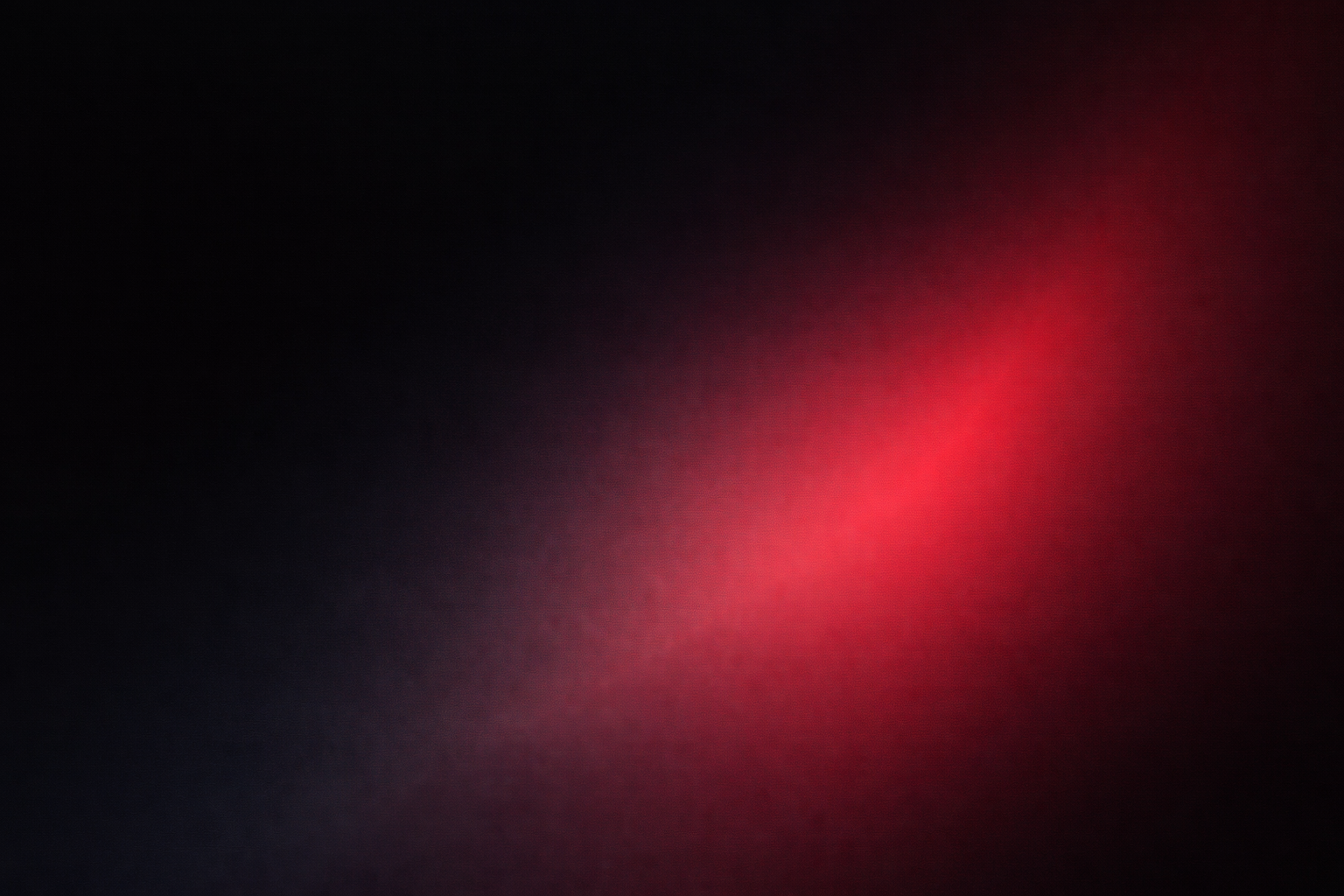 Abstract dark background with a soft red light spot in the center.