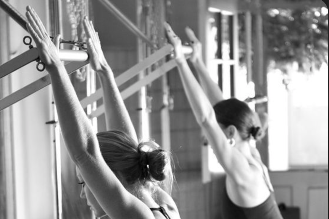 Zwei Frauen beim Pilates mit Tower Geräten, schwarz-weiß