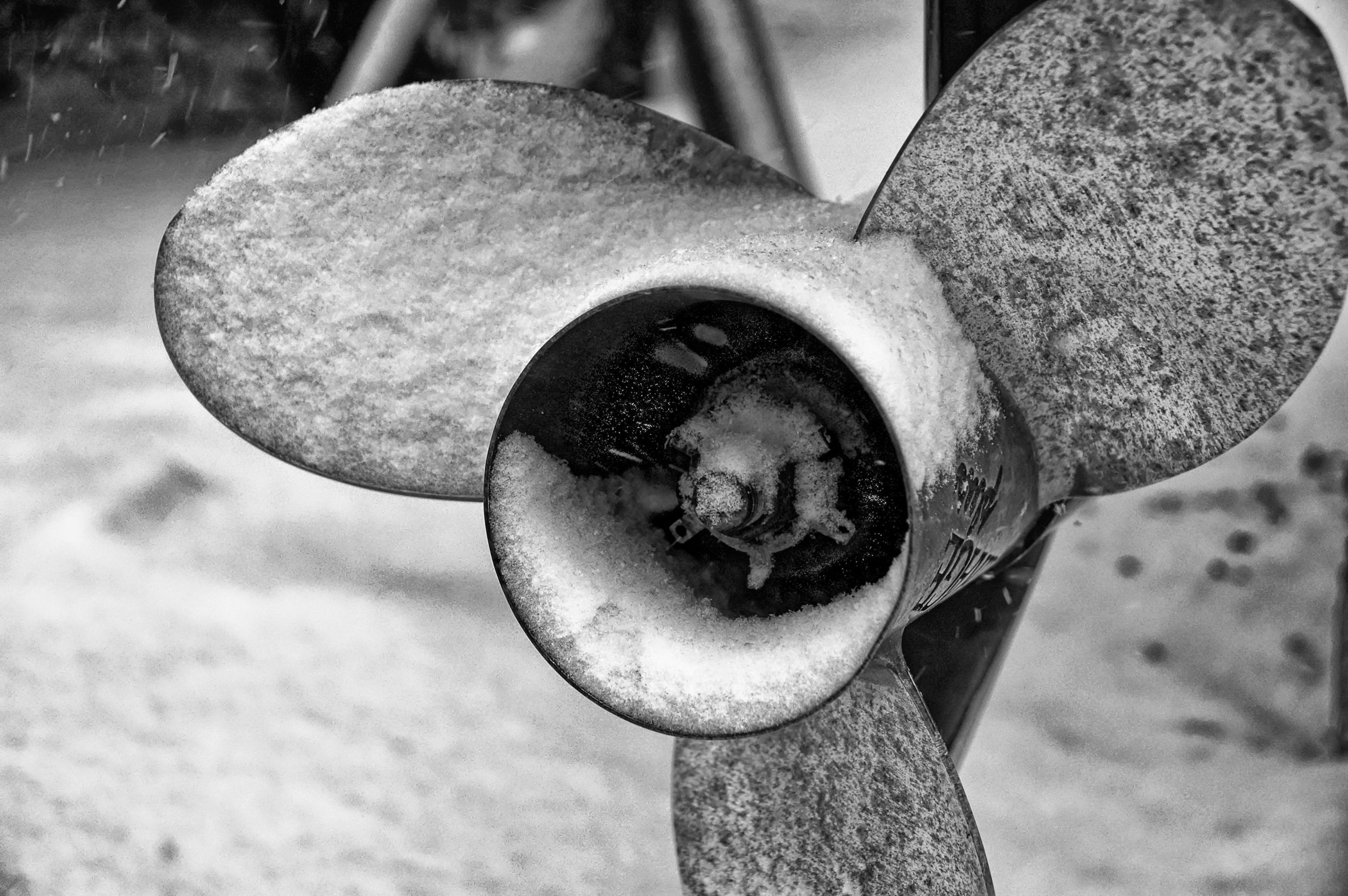 A close-up of a propeller with three large metal blades. 