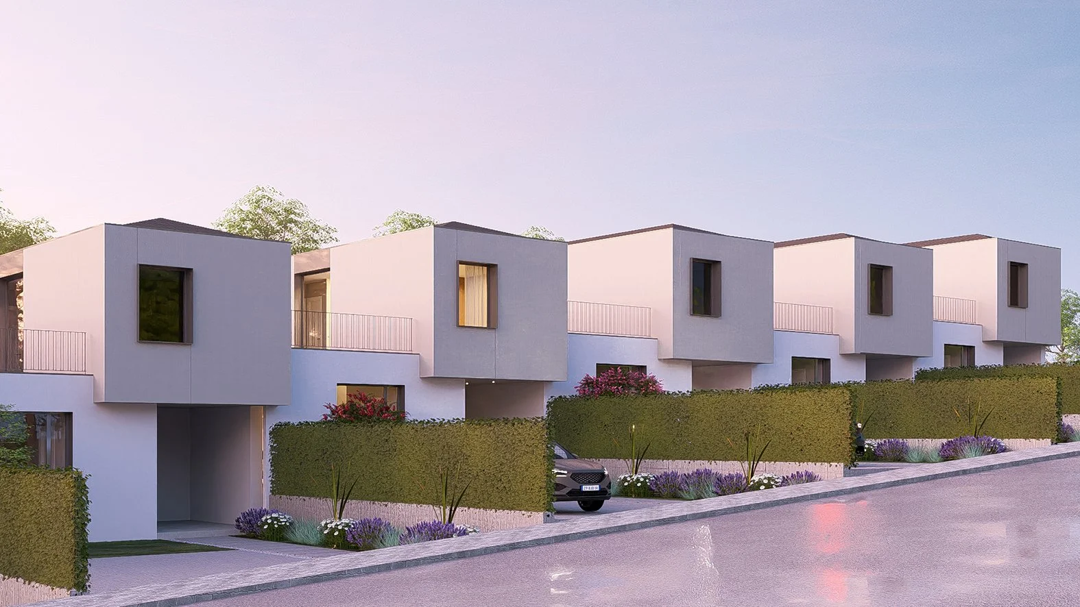 Conjunto de viviendas modernas de diseño minimalista, con fachadas blancas, ventanas rectangulares y jardines con plantas y flores en la entrada, en un entorno urbano y tranquilo.