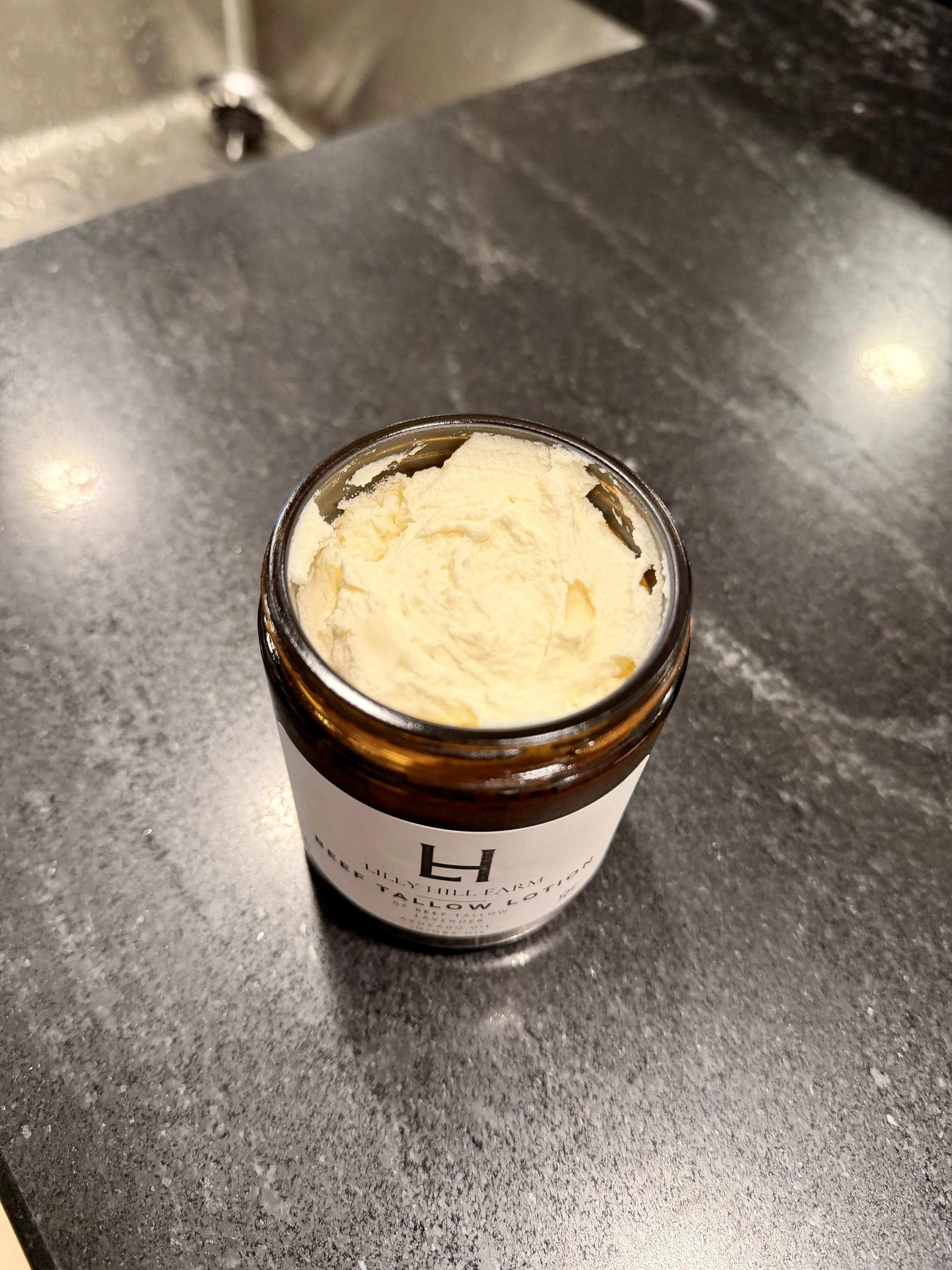 A jar of vanilla ice cream on a black countertop.