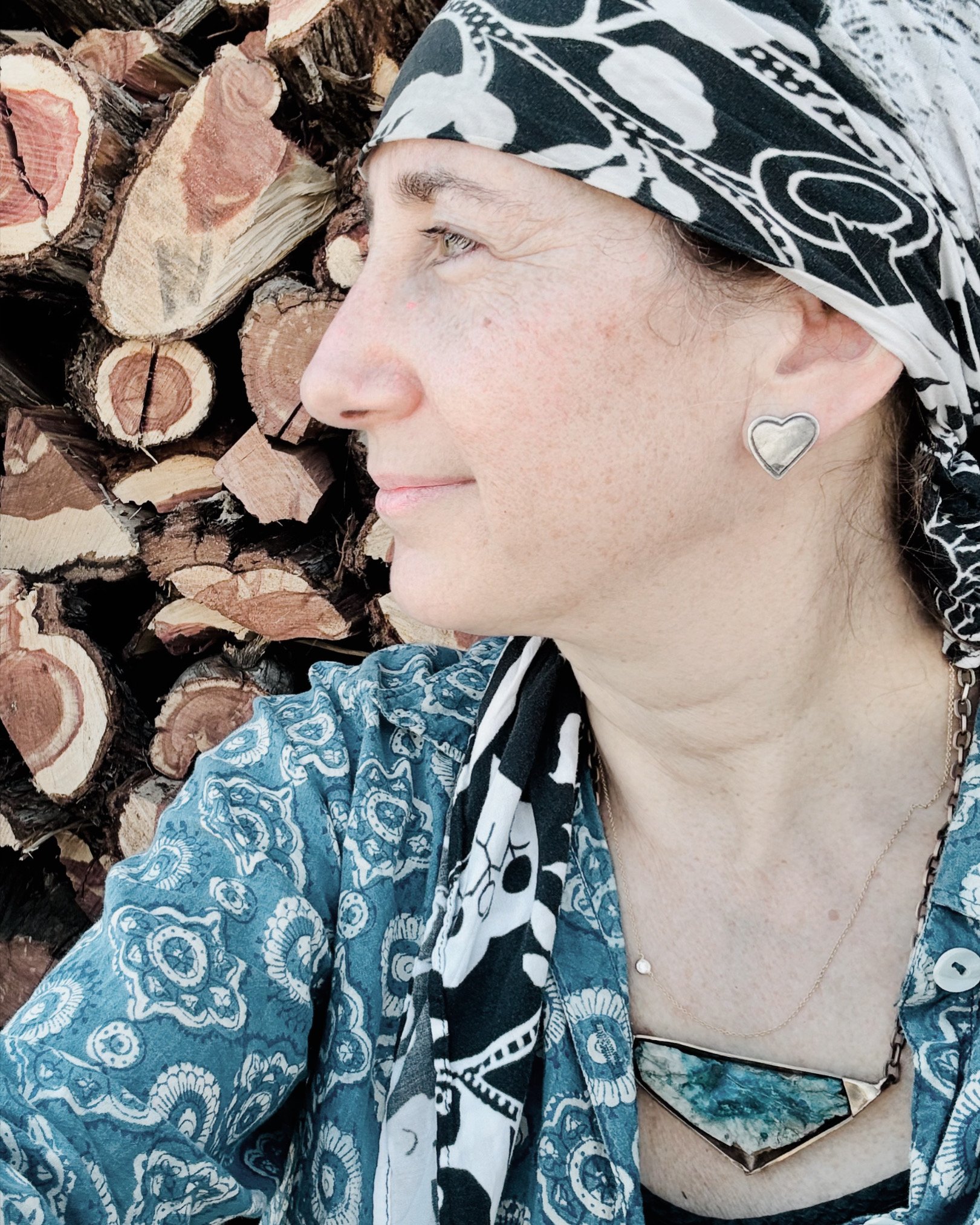 Close-up portrait of Jenna Ritter beside a stack of firewood.