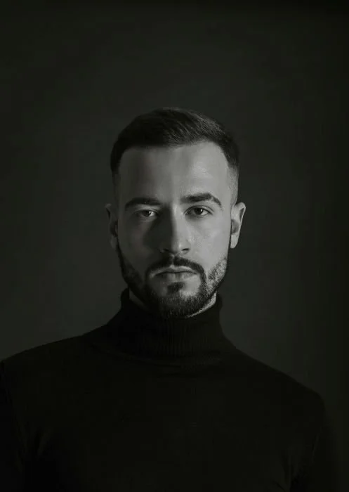 Portrait view of man with a beard wearing a turtleneck