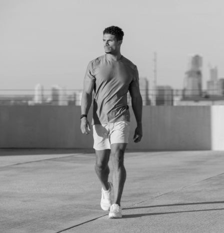 Young man walking outside towards the camera looking to the side