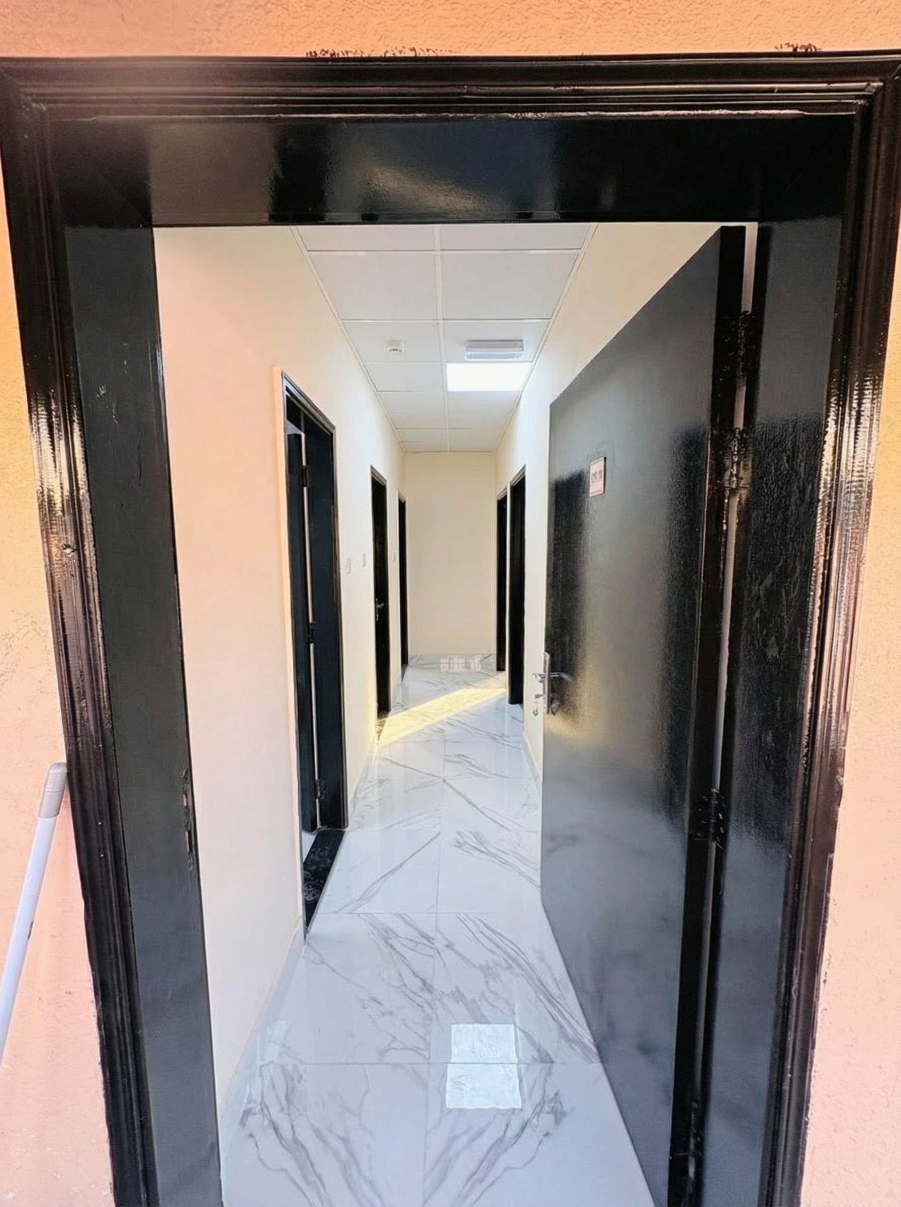 Professional apartment hallway with marble tiling in Al Jurf Industrial 1 Ajman NDYT corporate residences.