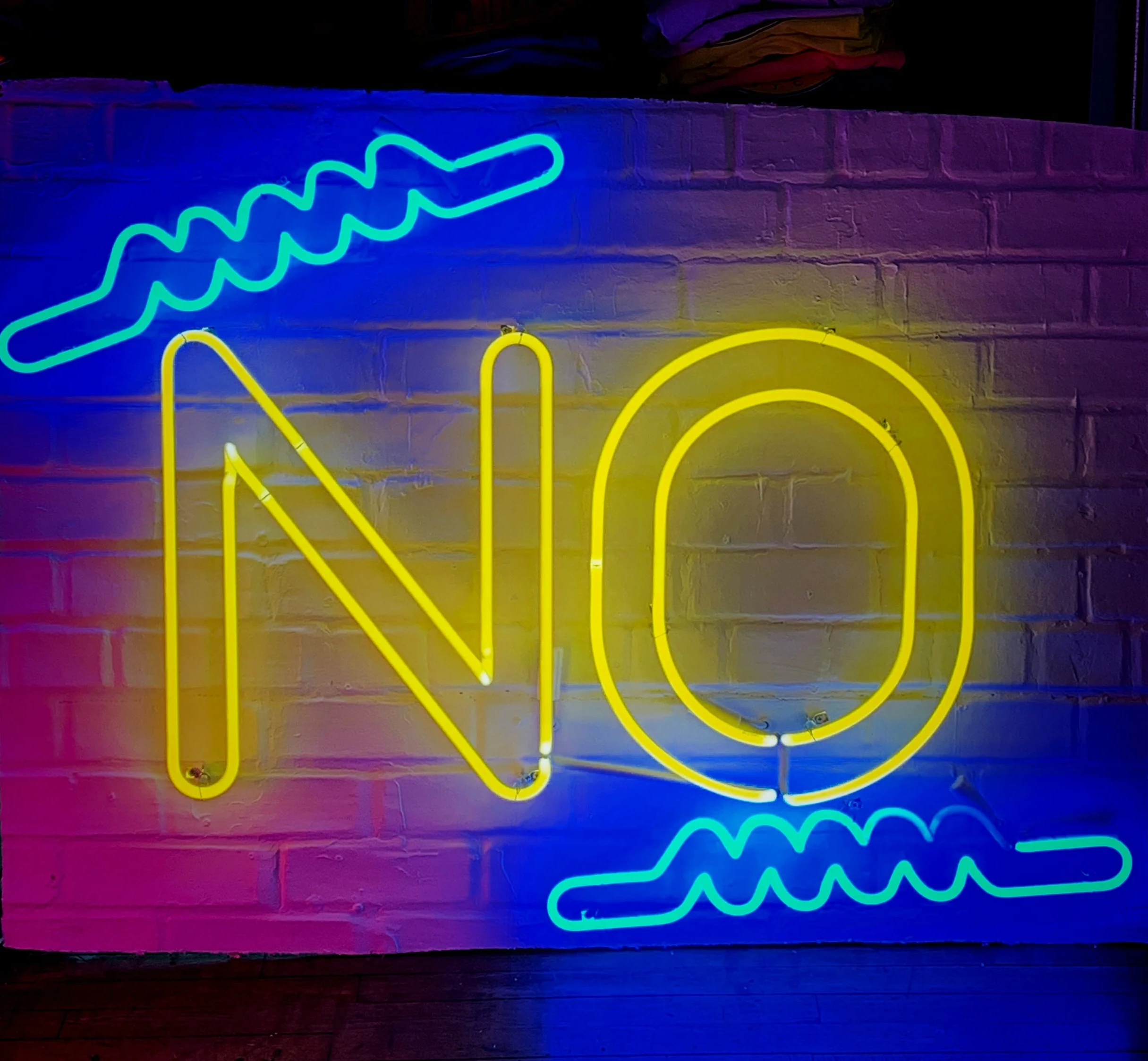 Bright neon sign spelling “No,” representing the concept of orgasm denial and intentional restraint in pleasure exploration