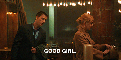 Dominant man praising submissive woman in bar