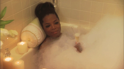 Woman relaxing in a bubble bath with candles, symbolising self-care and personal boundaries.
