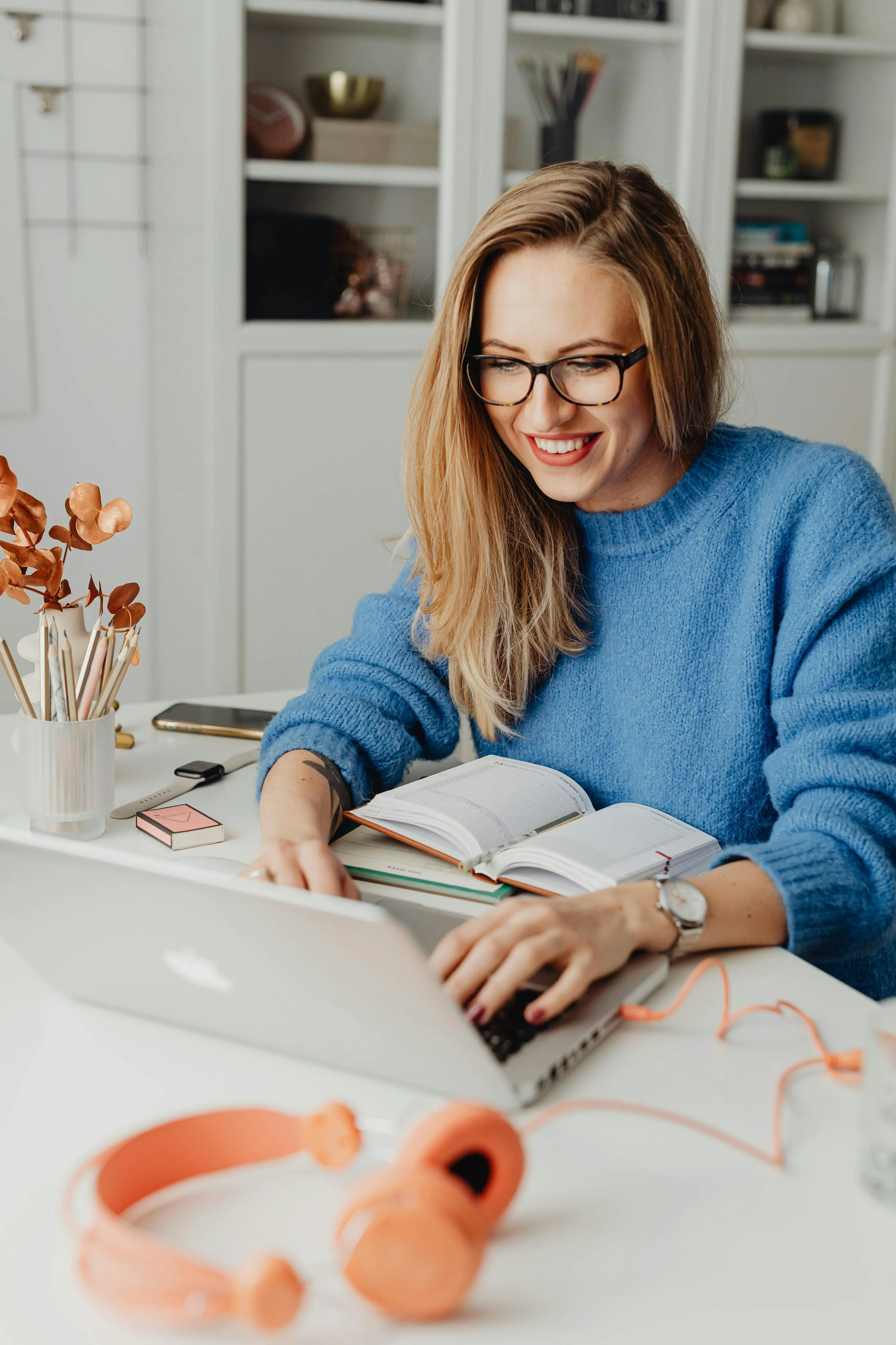 Woman sitting at a desk using a laptop, representing a welcoming and supportive space for therapy