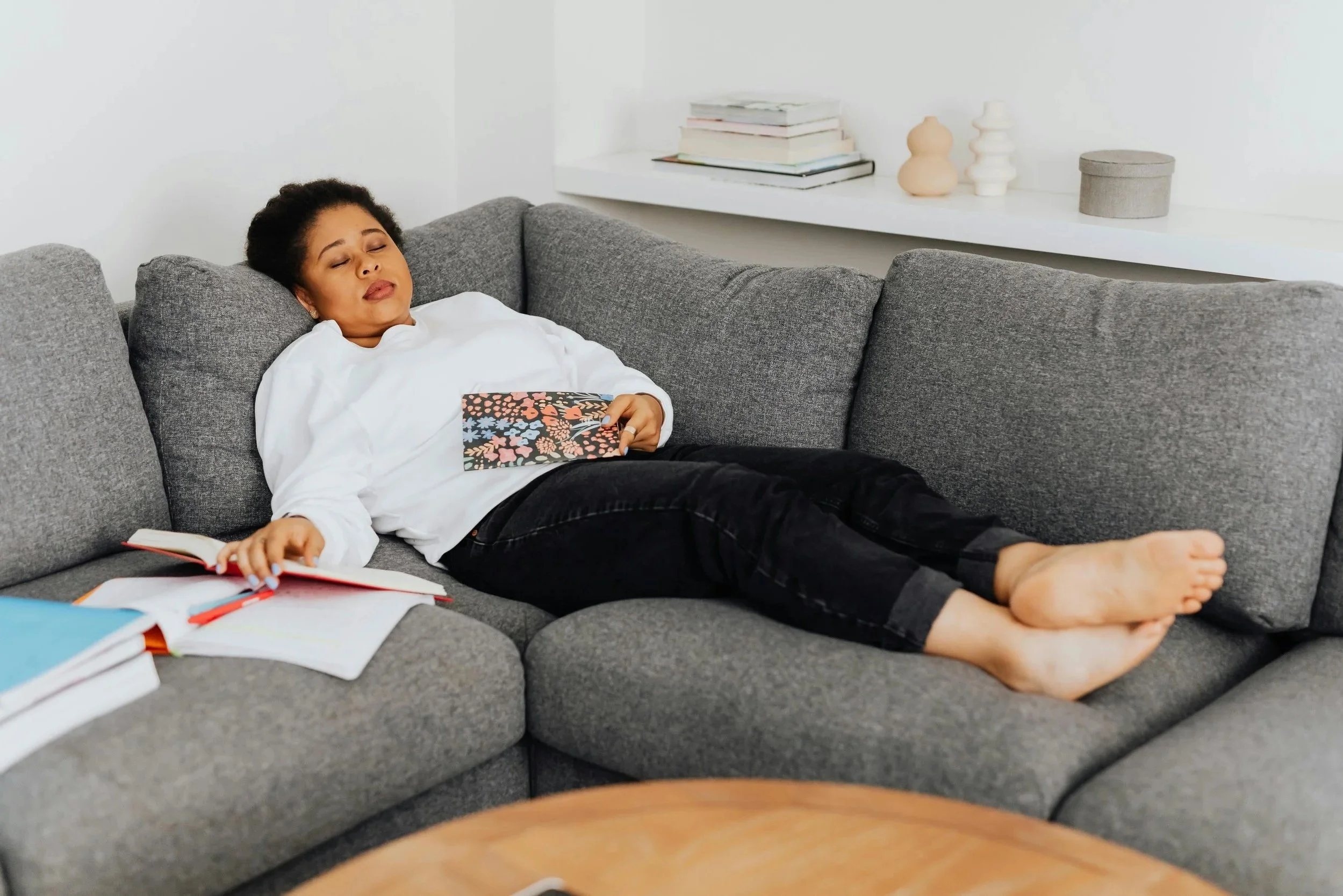 Tired woman resting on a couch after pushing through anxiety and overwork.