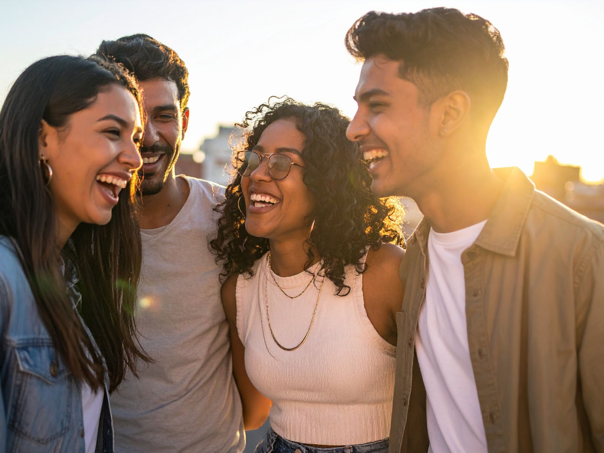Diverse group of friends laughing together, representing connection and support in anxiety therapy.