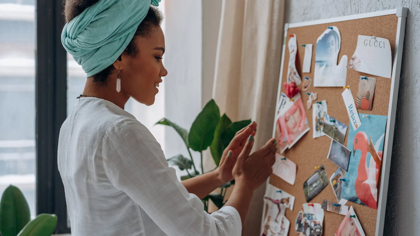 Woman creating a collage or vision board, representing reflection and rebuilding in depression therapy.
